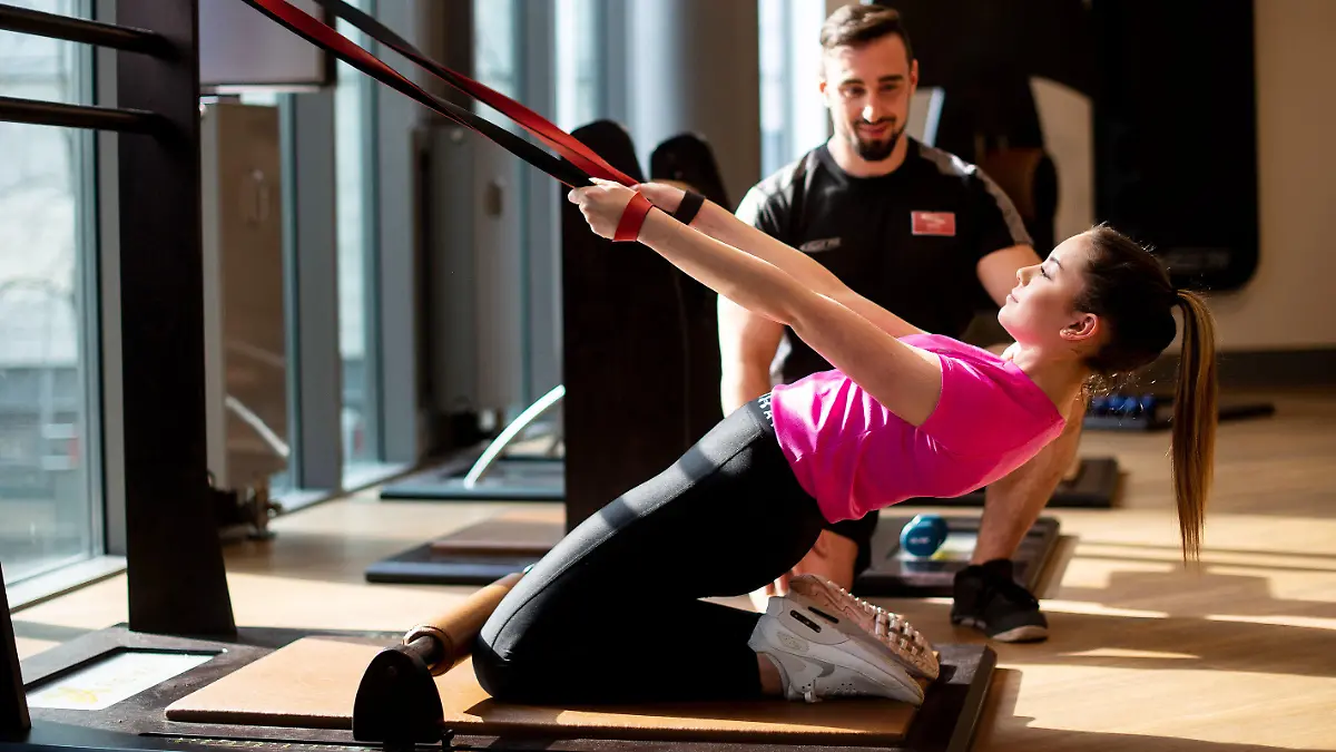 02.04.2019, Nordrhein-Westfalen, Köln: Personal Trainer Matthias zeigt Model Desiree während eines Pressetermins auf der Fitnessmesse FIBO verschiedene Fitnessübungen. Die FIBO sieht sich als weltgrößte Messe für Fitness, Wellness und Gesundheit. Vom 4. bis 7. April 2019 zeigen in Köln mehr als 1.100 Aussteller aus Europa und anderen Weltregionen ihre Neuheiten. Foto: Marius Becker/dpa +++ dpa-Bildfunk +++