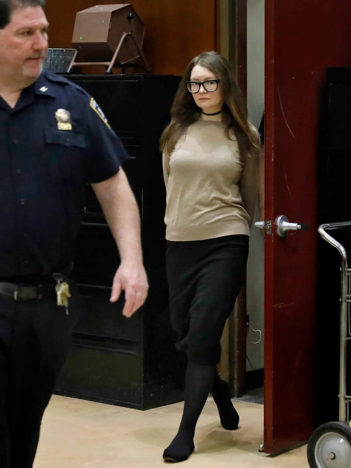 27.03.2019, USA, New York: Anna Sorokin, mutmaßliche Hochstaplerin aus Deutschland, kommt nach einer Prozessunterbrechung zurück in den Gerichtssaal. Sorokin, die unter dem Pseudonym Anna Delvey auftrat, soll New Yorker Hotel- und Geschäftspartner um Hunderttausende Dollar betrogen haben. Ihr wird mehrfacher schwerer Diebstahl vorgeworfen, im Fall einer Verurteilung droht ihr eine jahrelange Haftstrafe. Foto: Richard Drew/AP/dpa +++ dpa-Bildfunk +++