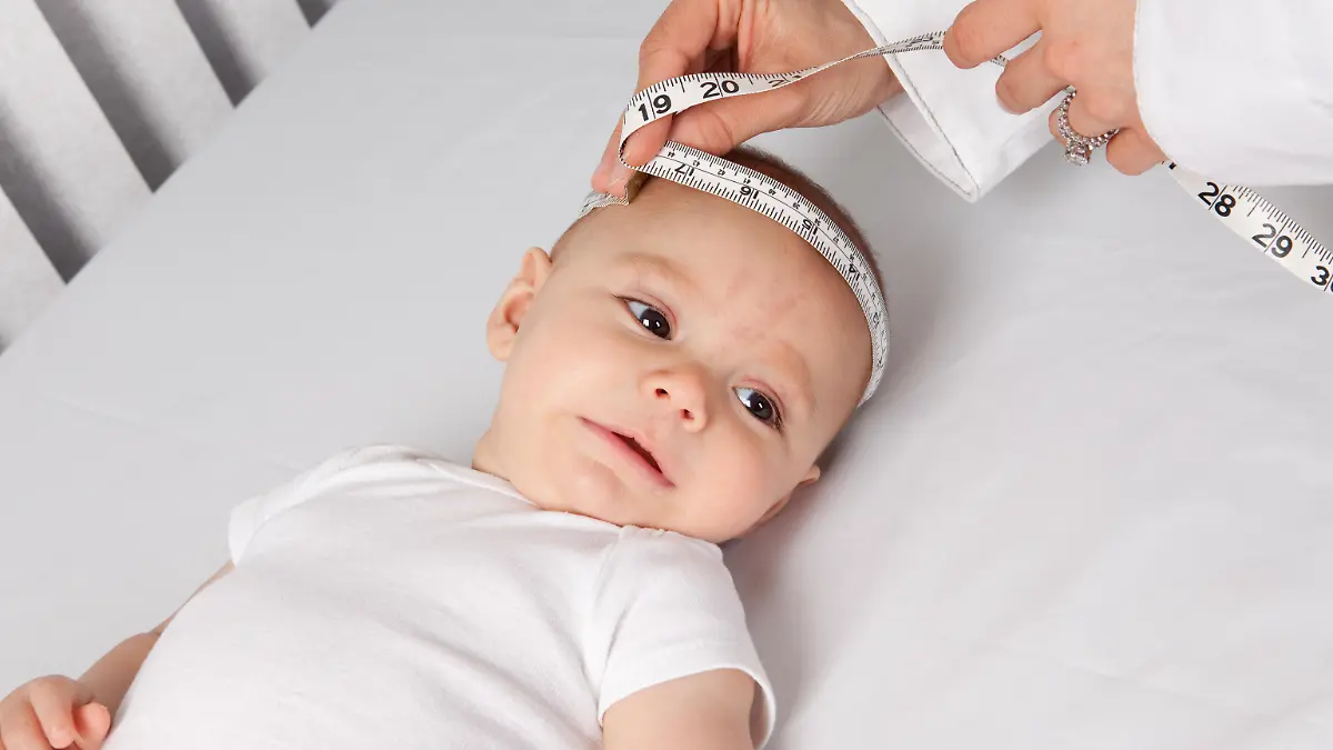 Kinderarzt misst den Kopfumfang des Babys