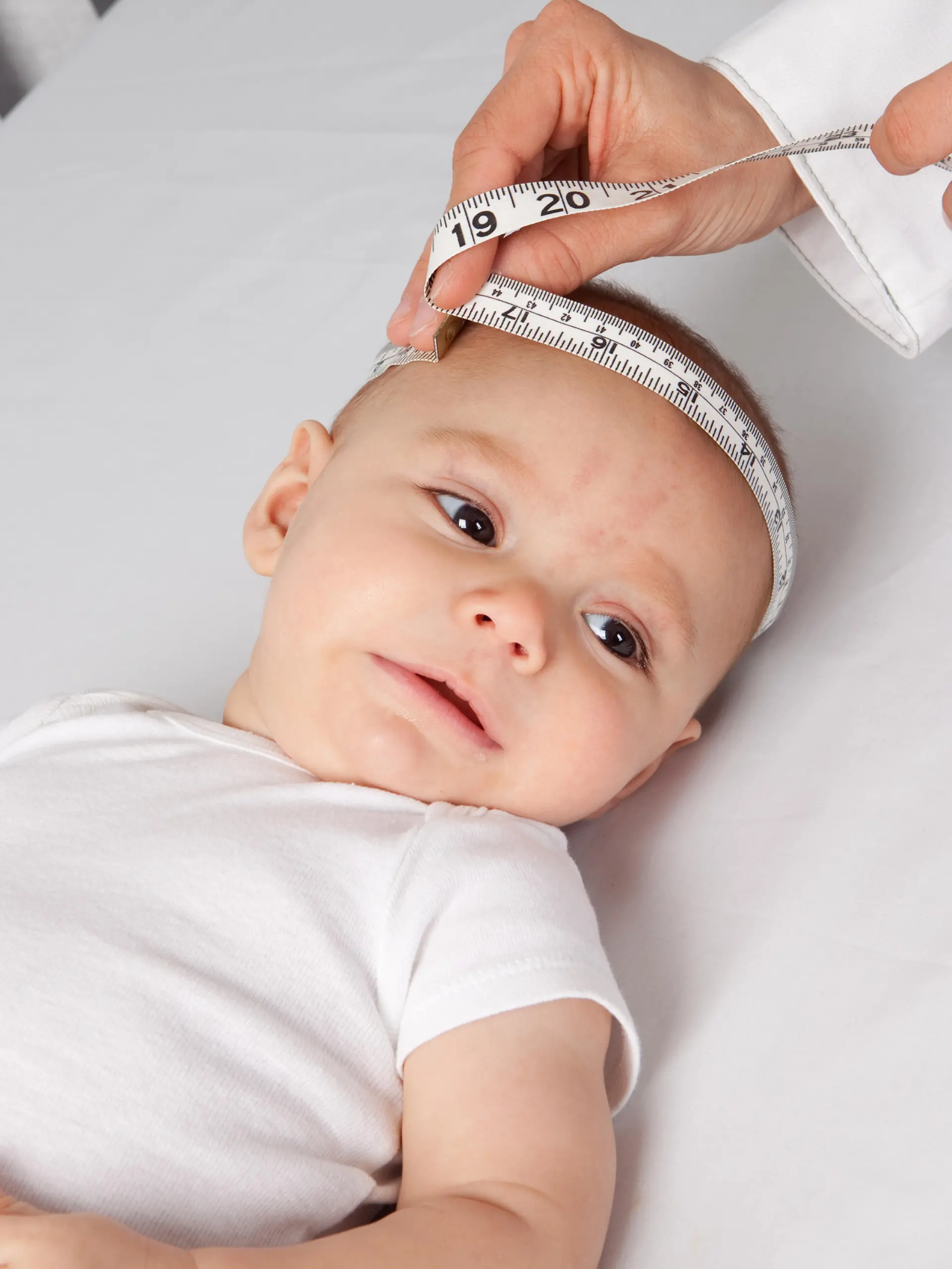 Kinderarzt misst den Kopfumfang des Babys