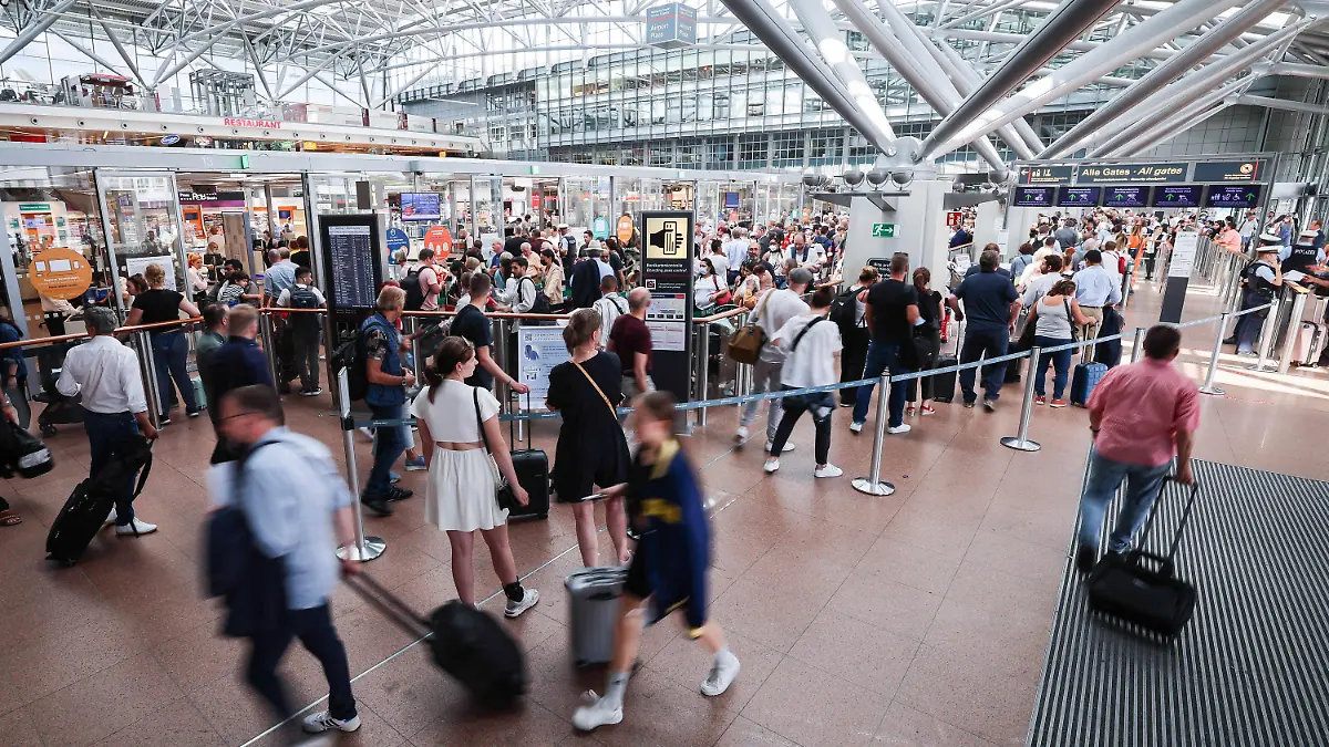 30.06.2022, Hamburg: Flugreisende warten in langen Schlangen an der Sicherheitskontrolle im Airport Hamburg. Mit dem Beginn der Sommerferien in Schleswig-Holstein, Mecklenburg-Vorpommern und Hamburg erwartet der Flughafen der Hansestadt einen Ansturm von Passagieren Foto: Christian Charisius/dpa +++ dpa-Bildfunk +++