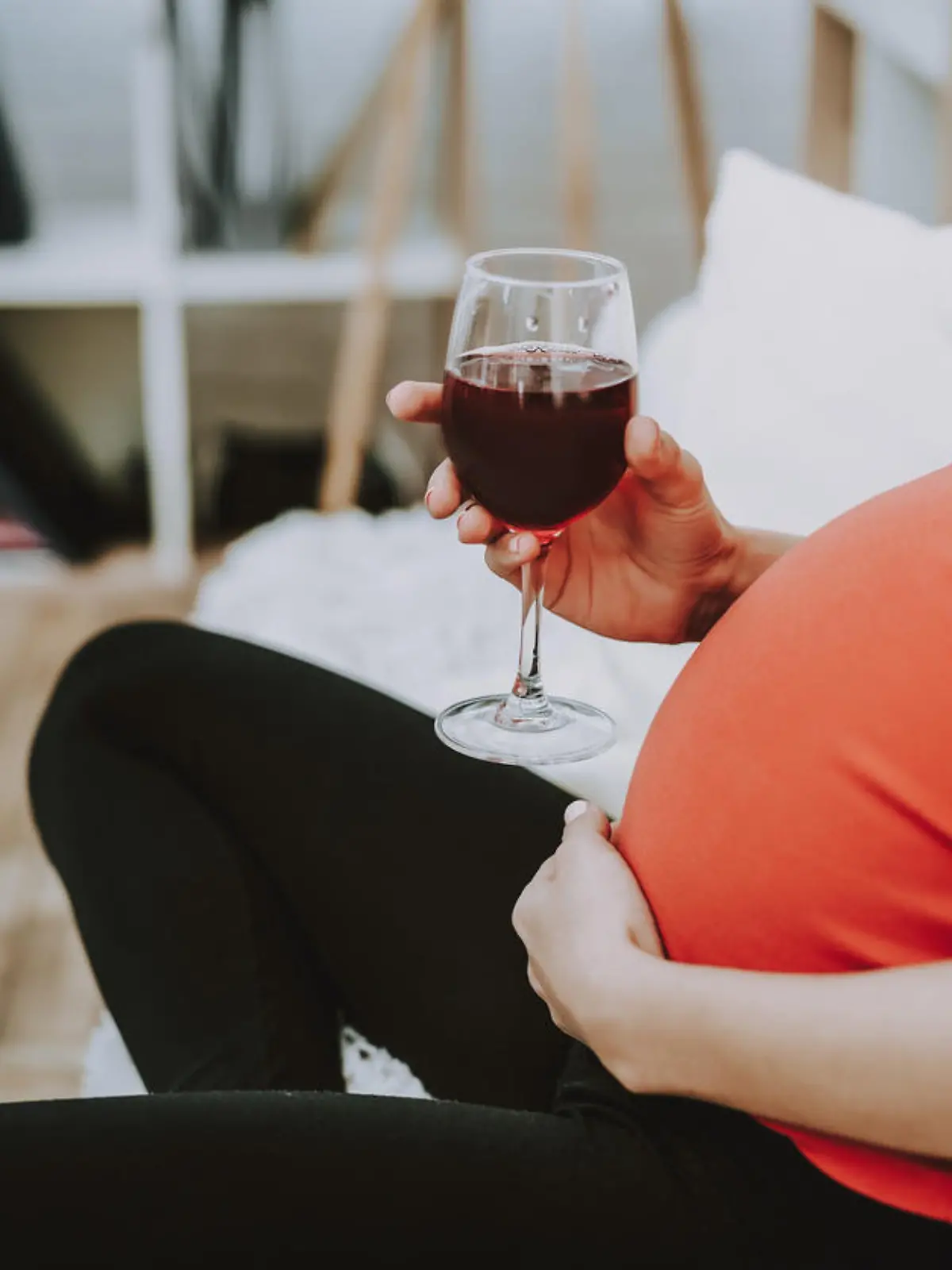 Schwangere Frau trinkt einen Wein.