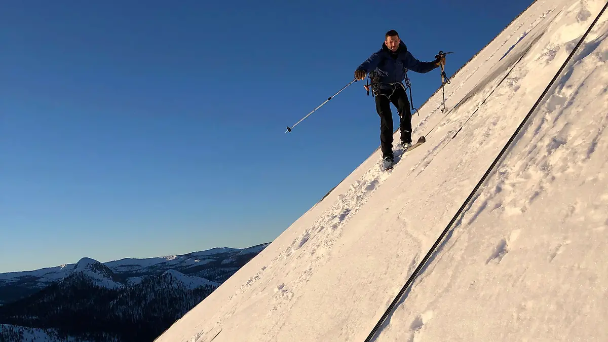 In this photo provided by Jason Torlano, Zach Milligan is shown on his descent down Half Dome in Yosemite National Park, Calif., on Sunday, Feb. 21, 2021. Two men climbed some 4,000 feet to the top of Yosemite's Half Dome in subfreezing temperatures and skied down the famously steep monolith to the valley floor. Jason Torlano, 45, and Zach Milligan, 40, completed the daring descent in five hours on Sunday by charging down Half Dome's arching back and using ropes to rappel down several sections of bare rock known as the "death slabs," the Fresno Bee reported on Thursday. (Jason Torlano via AP)