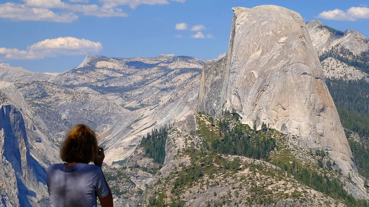 A visitor snaps photos of Half Dome from Washburn Point in Yosemite National Park on Aug. 4, 2021. The peak of Half Dome is over 8,000 feet above sea level. (Mark Hume/Chicago Tribune/TNS/ABACAPRESS.COM - NO FILM, NO VIDEO, NO TV, NO DOCUMENTARY