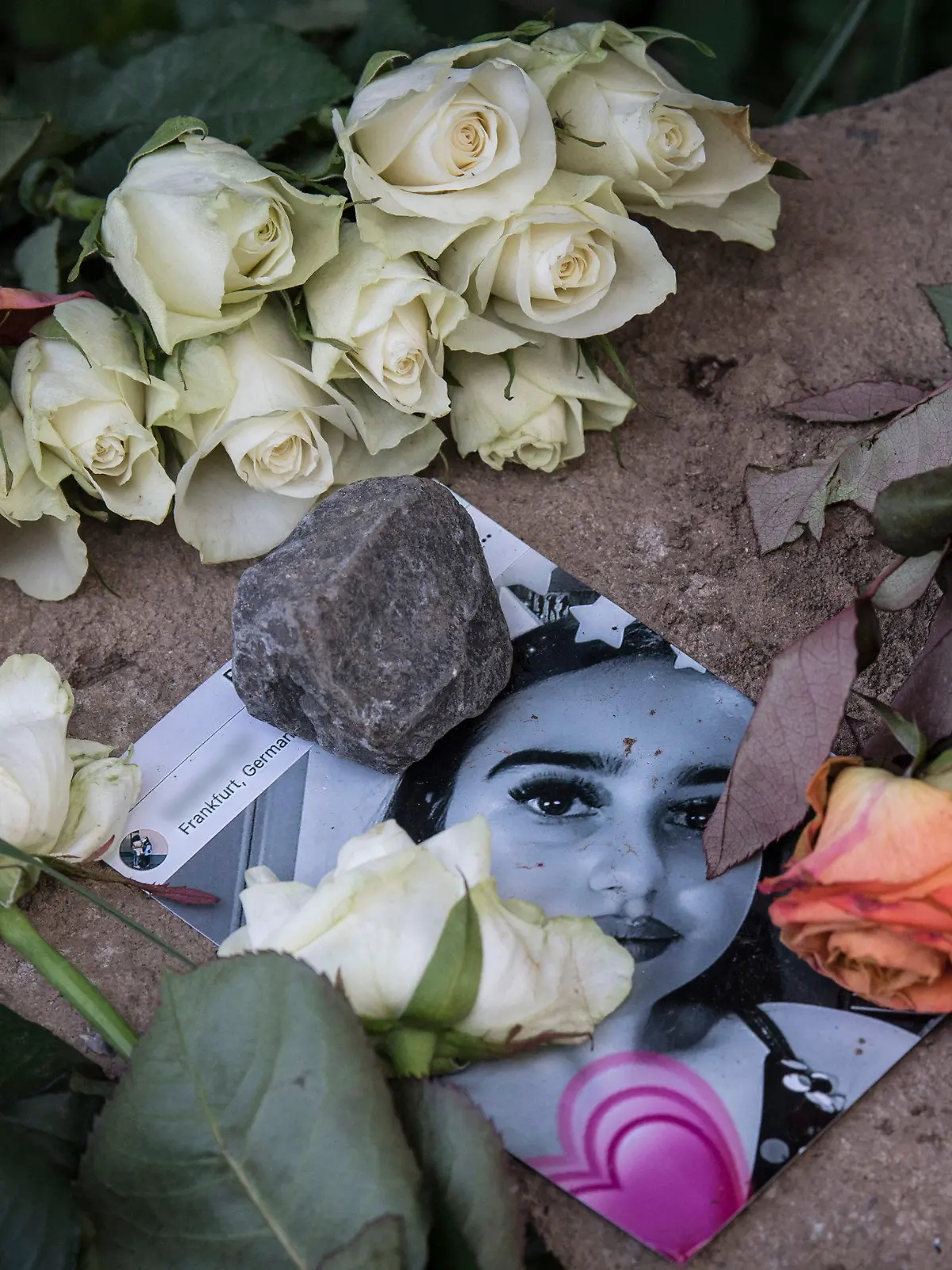 dpatopbilder - 08.06.2018, Hessen, Wiesbaden: Blumen liegen neben und auf einem Foto in der Nähe des Leichenfundortes von Susanna F. Die 14-jährige wurde Opfer eines Sexualdeliktes. Der mutmaßliche Täter hat sich in sein Heimatland Irak abgesetzt. (KEIN AUSSCHNITT) Foto: Boris Roessler/dpa +++ dpa-Bildfunk +++