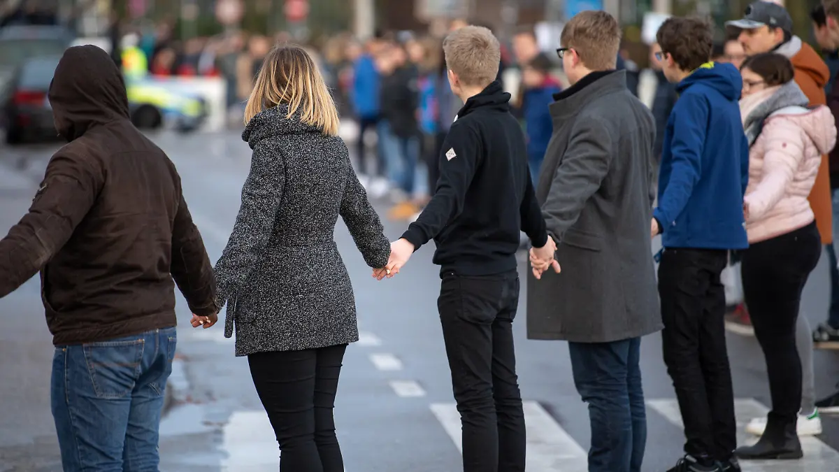 11.03.2019, Baden-Württemberg, Winnenden: Schülerinnen und Schüler stehen während der Gedenkfeier zum 10. Jahrestag des Amoklaufs von Winnenden in einer Menschenkette. Ein ehemaliger Schüler hatte am 11. März 2009 in der Albertville-Realschule sowie auf der anschließenden Flucht 15 Menschen erschossen. Foto: Sebastian Gollnow/dpa +++ dpa-Bildfunk +++