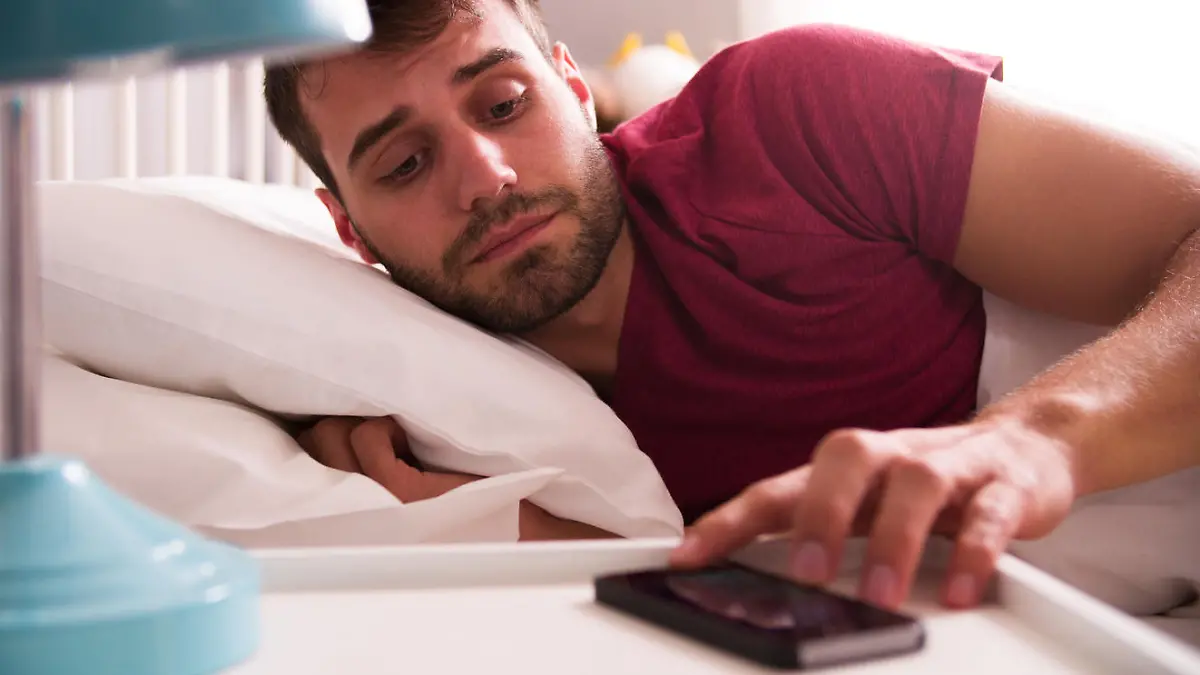 Mann stellt Wecker auf Smartphone