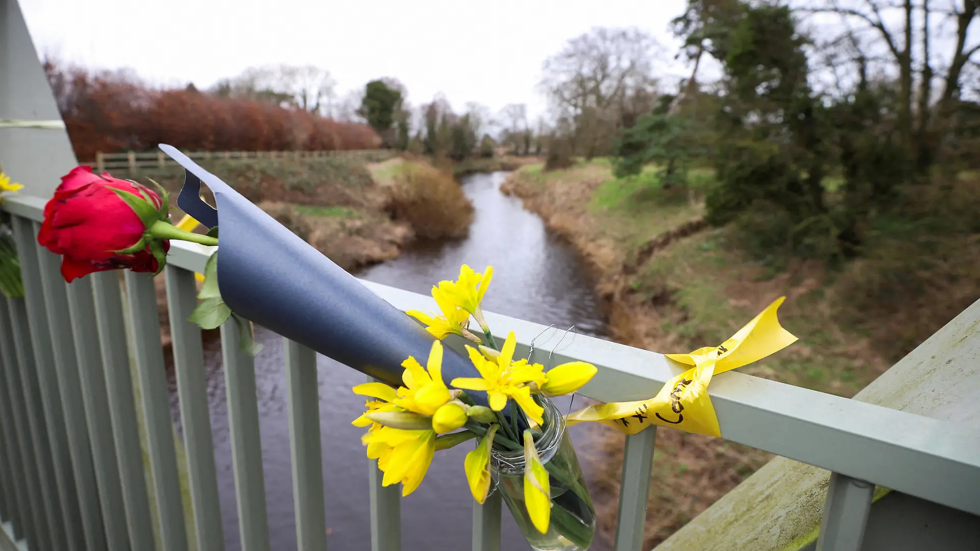 A view of flowers and a ribbon with a message on a bridge over the River Wyre near the scene where a body, that is suspected to be missing woman Nicola Bulley, was found in Lancashire, Britain February 20, 2023. REUTERS/Phil Noble TPX IMAGES OF THE DAY