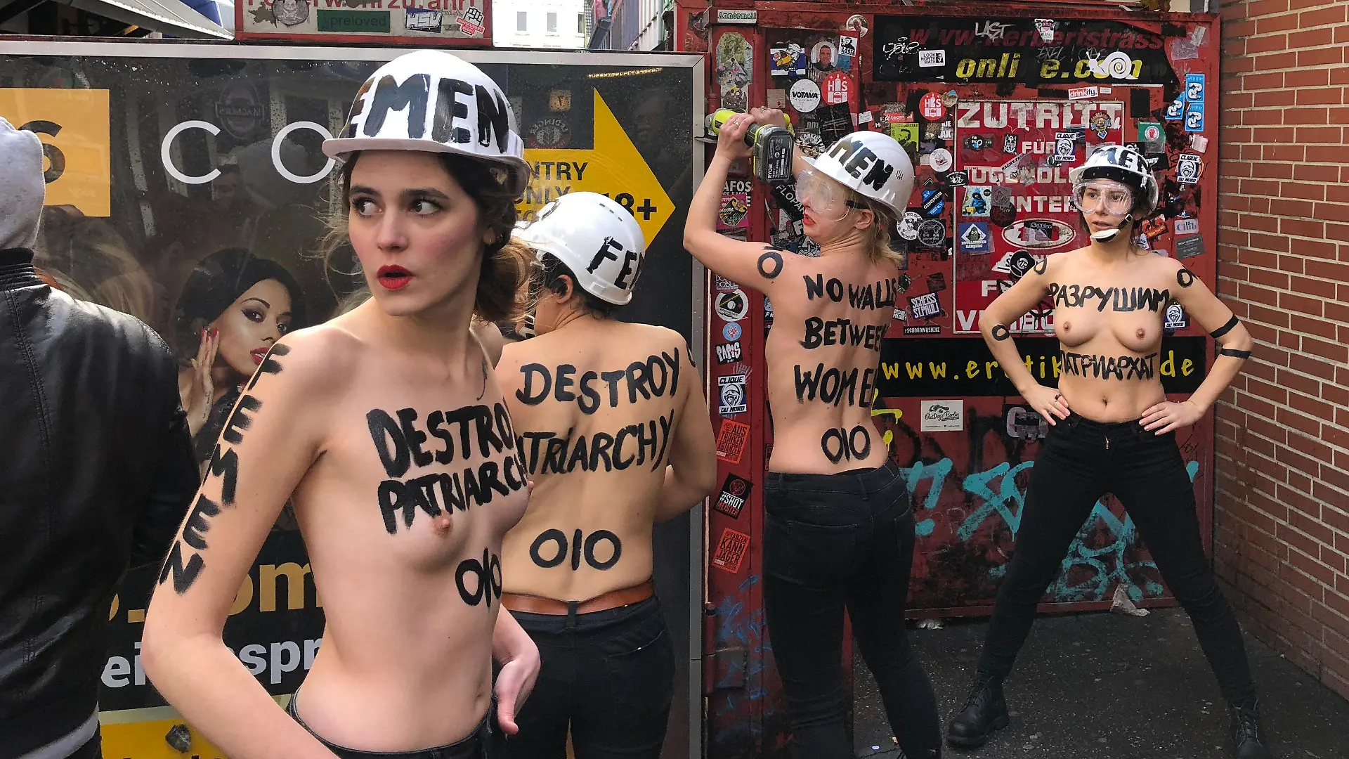 08.03.2019, Hamburg: Mit nacktem Oberkörper und einer Flex demontieren Aktivistinnen im Rotlichtviertel von St. Pauli einen Sichtschutz der Herbertstraße. Mit dieser Aktion will die Organisation Femen «die sexuelle Ausbeutung von Frauen, Menschenhandel und sexuelle Gewalt anprangern, die sich hinter den Toren und Türen der Sexindustrie versteckt», wie die Gruppe am Freitag auf ihrer Facebook-Seite mitteilte. (zu dpa "Halbnackte Frauen zerlegen Sichtschutz in Hamburgs Rotlichtviertel") Foto: Carina Lue/dpa +++ dpa-Bildfunk +++