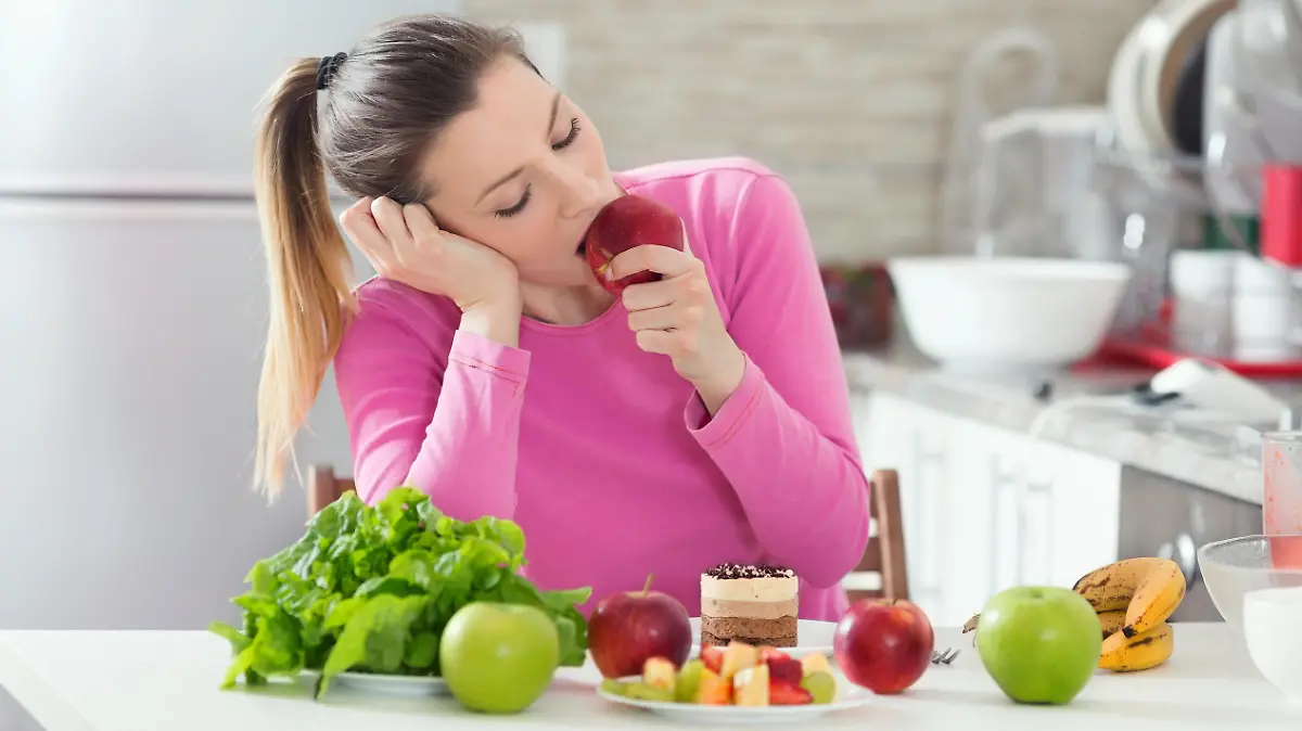 Frau sitzt mit Obst am Tisch