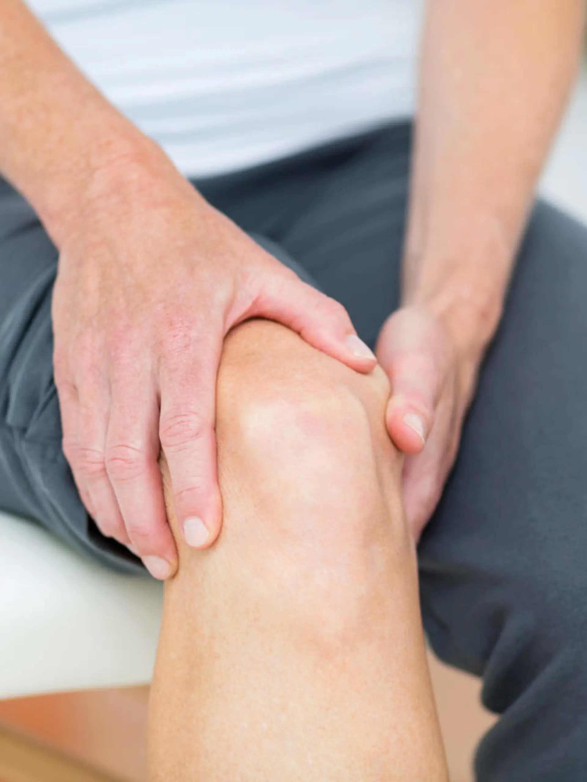 Eine Frau hält sich das Knie