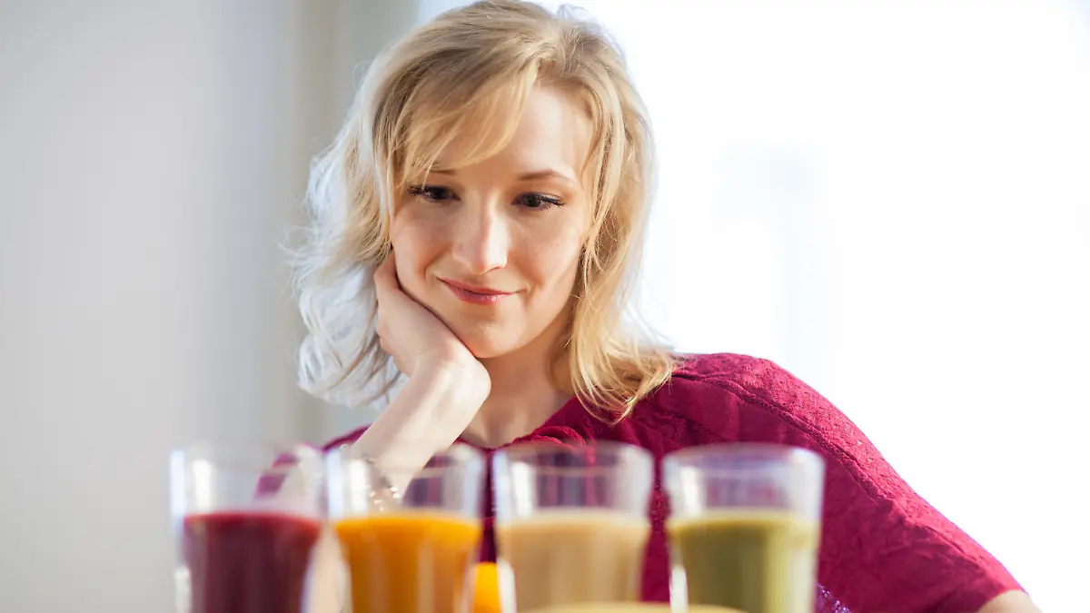 ILLUSTRATION - Eine junge Frau steht am 08.04.2016 in Hamburg in ihrer Kueche und ueberlegt, welchen Smoothie sie trinken soll. Foto: Christin Klose | Verwendung weltweit