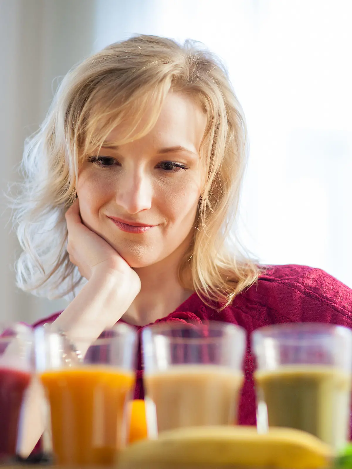 ILLUSTRATION - Eine junge Frau steht am 08.04.2016 in Hamburg in ihrer Kueche und ueberlegt, welchen Smoothie sie trinken soll. Foto: Christin Klose | Verwendung weltweit