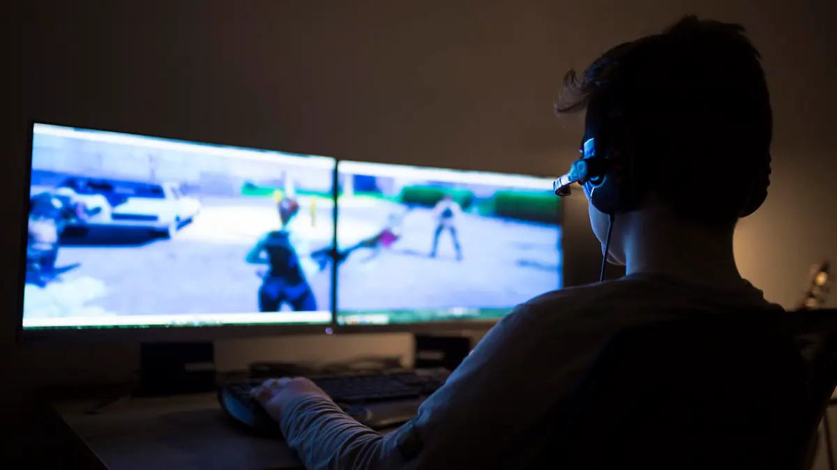 Ein Junge spielt im Dunkeln Computerspiele