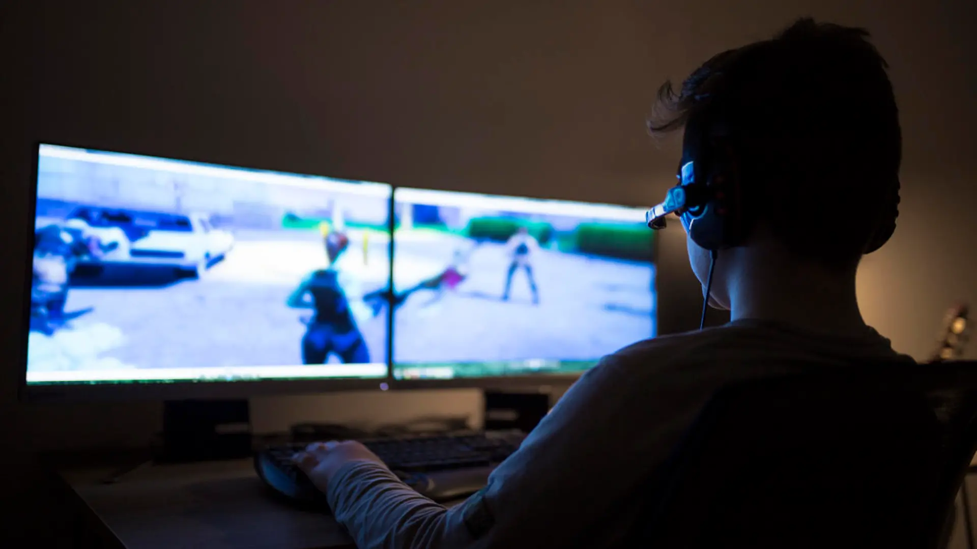 Ein Junge spielt im Dunkeln Computerspiele
