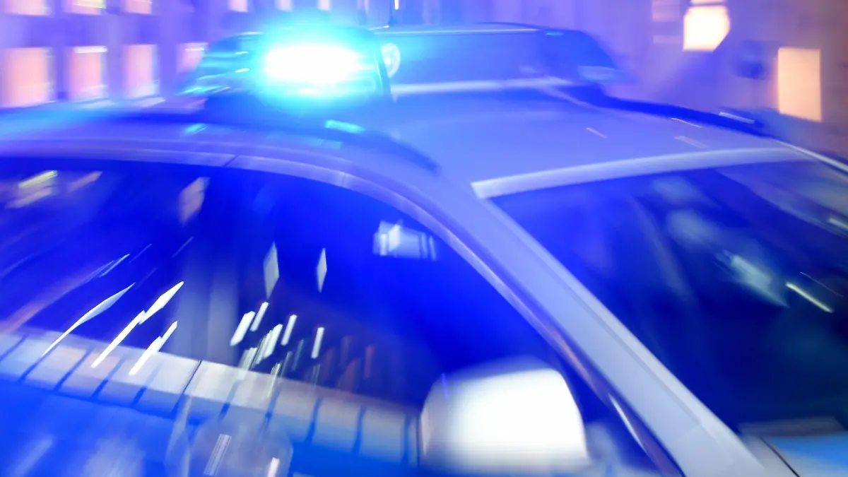 ARCHIV - ILLUSTRATION - 06.08.2015, Schleswig-Holstein, Flensburg: Ein Streifenwagen der Bundespolizei steht mit eingeschaltetem Blaulicht in Flensburg (Schleswig-Holstein) in der Ausfahrt einer Garage. Nach dem gewaltsamen Tod einer 17-Jährigen in Flensburg ist gegen einen 18-jährigen Tatverdächtigen Haftbefehl erlassen worden. Dies teilte ein Sprecher des polizeilichen Lagezentrums in Kiel in der Nacht zum 14.03.2018 mit. Das Mädchen war am 12.03.2018 in einer Wohnung mit schweren Stichverletzungen aufgefunden worden. (zu dpa "Haftbefehl nach gewaltsamen Tod von 17-Jähriger erlassen" vom 14.03.2018) Foto: Carsten Rehder/dpa +++ dpa-Bildfunk +++