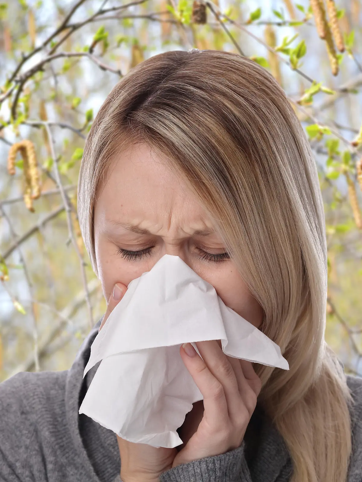 Frau niest mit Taschentuch Frühling Allergie