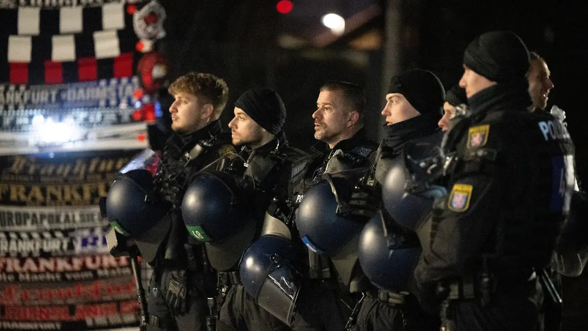 ARCHIV - 07.02.2023, Hessen, Frankfurt/Main: Polizeibeamte sichern die Ankunft von Fans des SV Darmstadt 98 am Stadion in Frankfurt. Die Begegnung mit Eintracht Frankfurt gilt wegen des angespannten Verhältnisses beider Fangruppen als Risikospiel. (zu dpa: «Polizei meldet Angriffe auf Neapel-Fans vor Eintracht-Spiel») Foto: Boris Roessler/dpa +++ dpa-Bildfunk +++