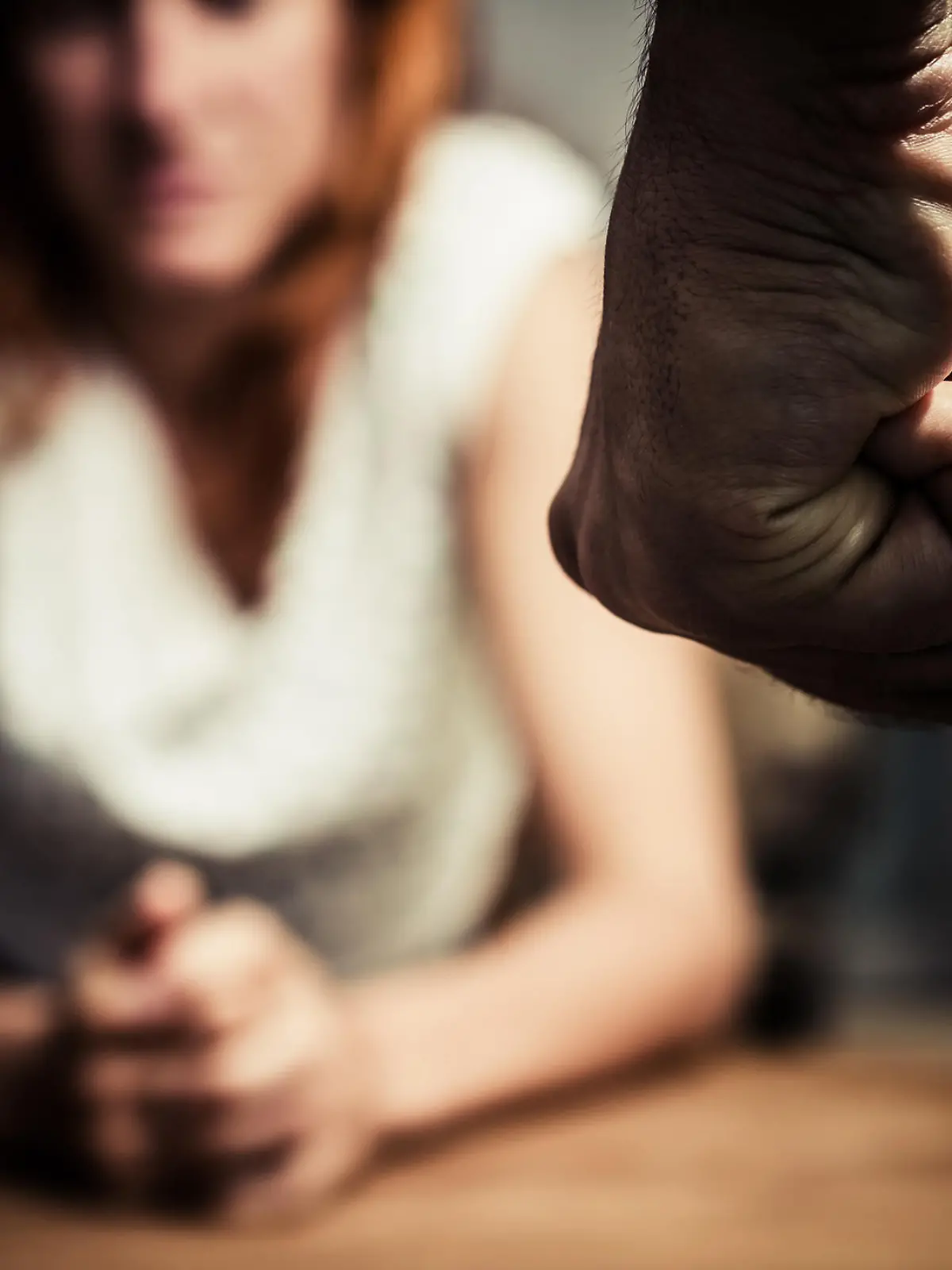 Mann steht mit geballter Faust vor Frau.