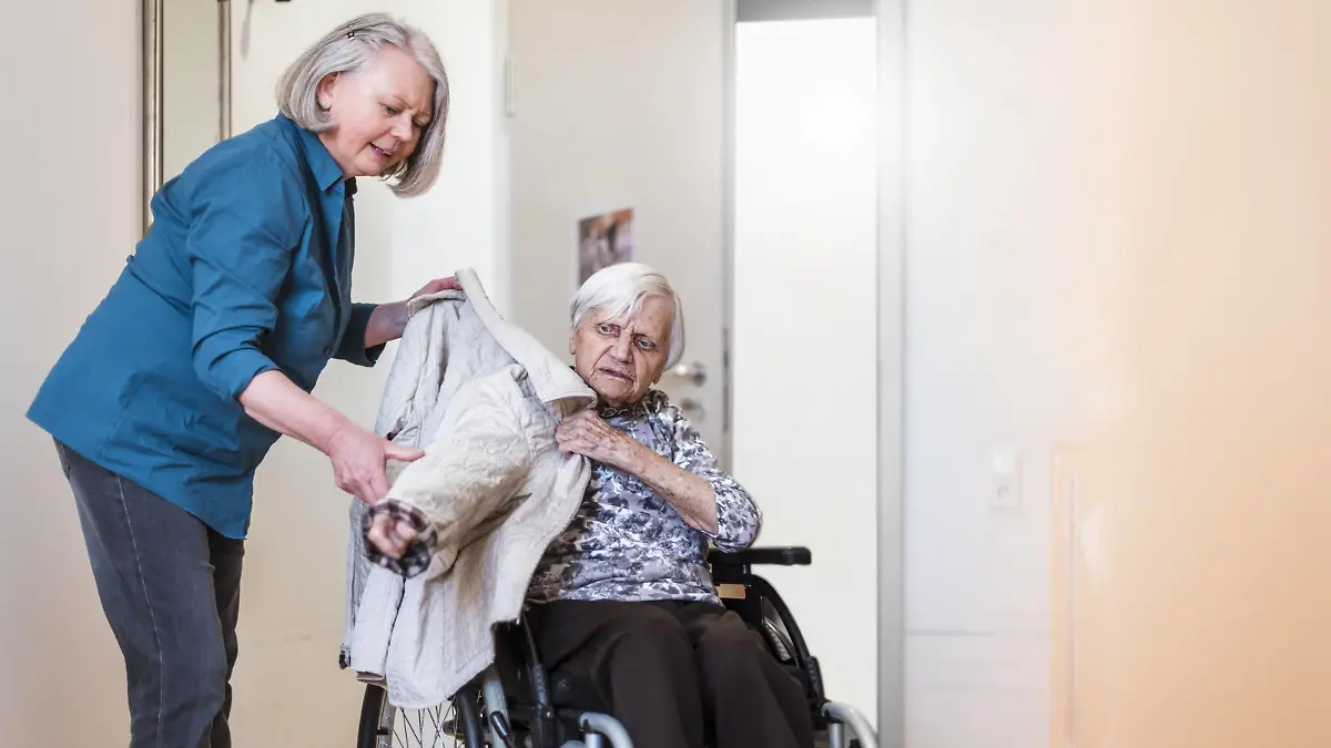 Woman taking care of old woman in wheelchair putting her jacket on model released Symbolfoto PUBLICATIONxINxGERxSUIxAUTxHUNxONLY DIGF04069  