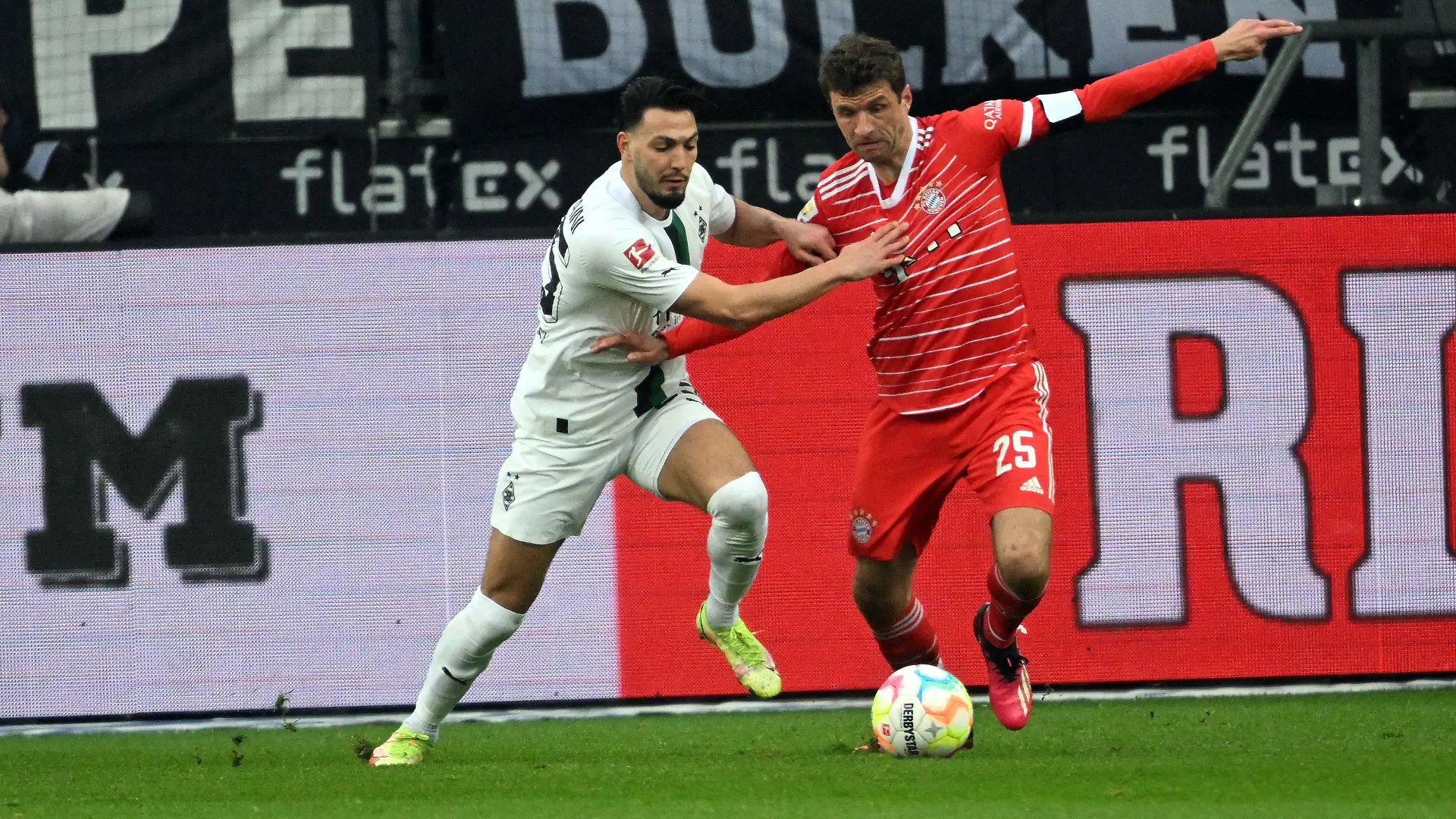 18.02.2023, Nordrhein-Westfalen, Mönchengladbach: Fußball: Bundesliga, Borussia Mönchengladbach - Bayern München, 21. Spieltag, Stadion im Borussia-Park: Mönchengladbachs Ramy Bensebaini (l) und Bayerns Thomas Müller kämpfen um den Ball. (zu dpa: «Frühste Auswechslung: Müller nimmt es hin, Hamann kritisiert») Foto: Federico Gambarini/dpa - WICHTIGER HINWEIS: Gemäß den Vorgaben der DFL Deutsche Fußball Liga bzw. des DFB Deutscher Fußball-Bund ist es untersagt, in dem Stadion und/oder vom Spiel angefertigte Fotoaufnahmen in Form von Sequenzbildern und/oder videoähnlichen Fotostrecken zu verwerten bzw. verwerten zu lassen. +++ dpa-Bildfunk +++