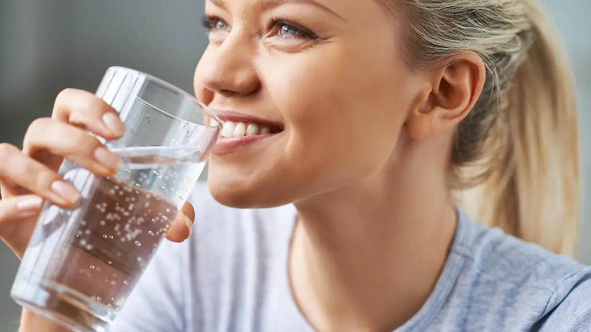 Beautiful young woman drinking water
