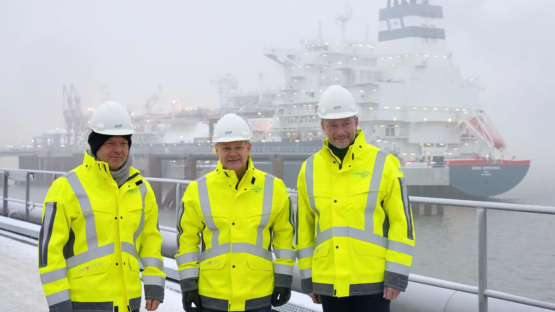 ARCHIV - 17.12.2022, Niedersachsen, Wilhelmshaven: Robert Habeck (Bündnis 90/Die Grünen, l-r), Bundesminister für Wirtschaft und Klimaschutz, Bundeskanzler Olaf Scholz (SPD) und Christian Lindner (FDP), Bundesfinanzminister, stehen vor dem Spezialschiff «Hoegh Esperanza» während der Eröffnung des LNG-Terminals in Wilhelmshaven. Bei der Energieversorgung, in der Arbeitswelt, bei Entscheidungen über Investitionen: Der Krieg in der Ukraine hat in der deutschen Wirtschaft alte Glaubenssätze eingerissen und neue Türen aufgestoßen. (zu dpa: «Was ein Jahr Krieg in der Wirtschaft bewegt hat - und was nicht») Foto: Michael Sohn/POOL AP/dpa +++ dpa-Bildfunk +++