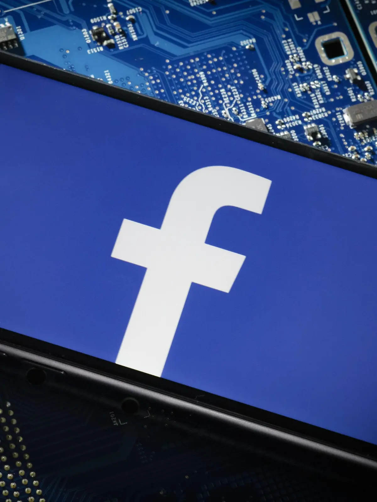Ein Smartphone liegt auf einer Computerplatine und zeigt das Logo von Facebook. Berlin, 20.03.2018. Berlin Deutschland *** A smartphone lies on a computer board and shows the logo of Facebook Berlin 20 03 2018 Berlin Germany PUBLICATIONxINxGERxSUIxAUTxONLY Copyright: xThomasxTrutschel/photothek.netx  
