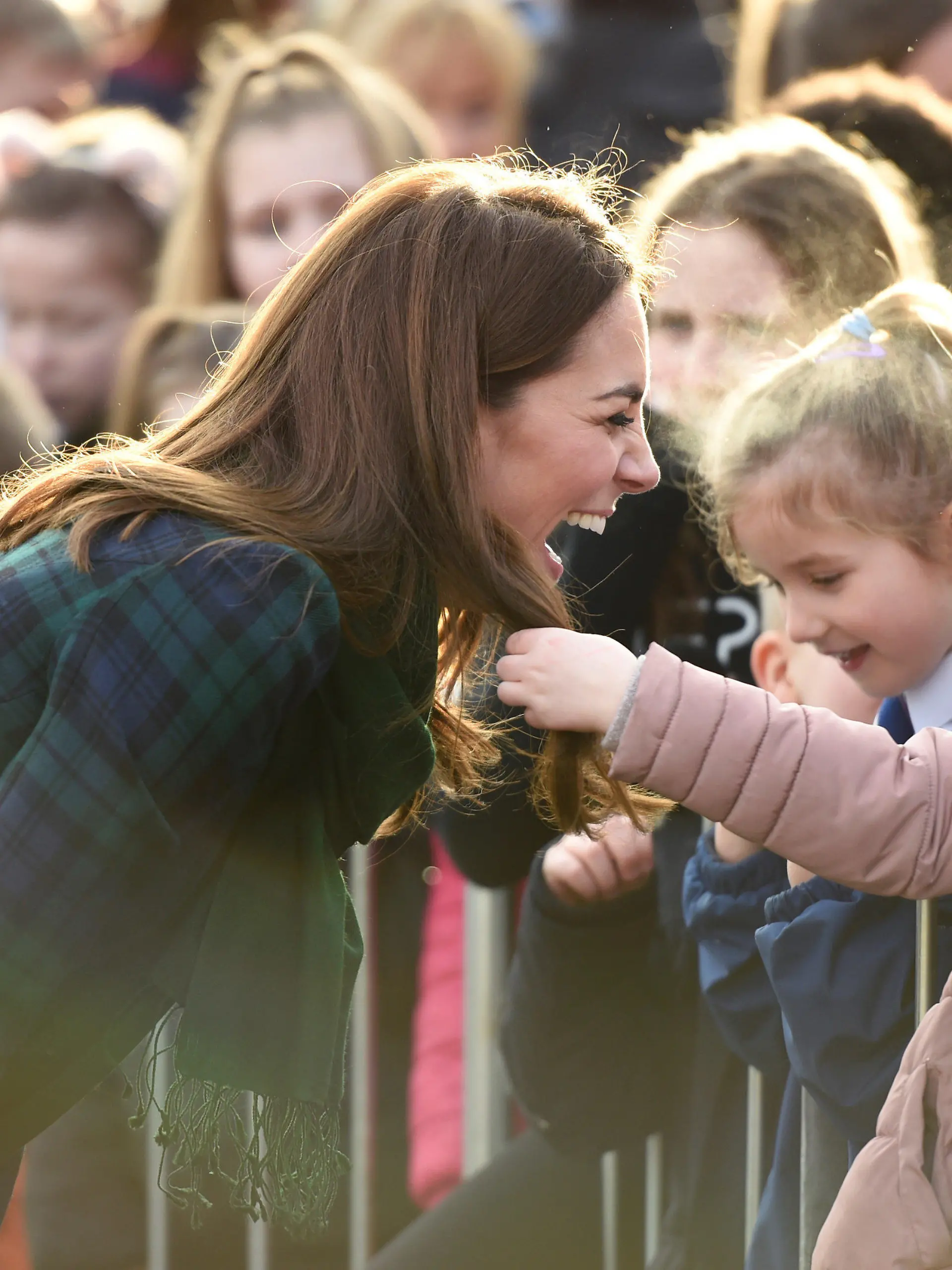 29.01.2019, Großbritannien, Dundee: Herzogin Kate (l) begrüßt vor einem Gemeindezentrum Kinder und lässt sie ihre Haare berühren. Foto: Ian Rutherford/PA Wire/dpa +++ dpa-Bildfunk +++
