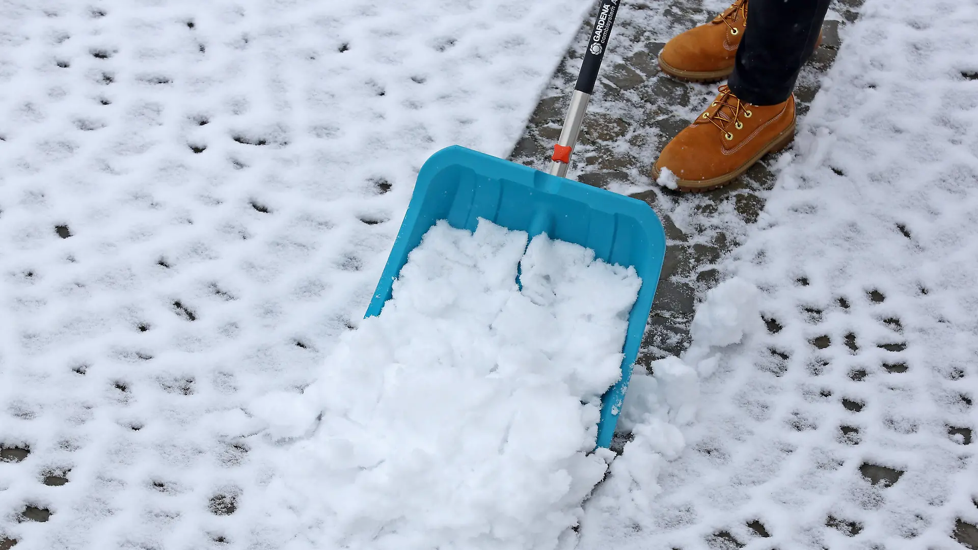 Nach den milden letzten Tagen ist der Winter zurueck im Siegerland, eine Frau schiebt Schnee, befreit das Grundstueck vom Schnee in Siegen-Oberschelden Winter im Siegerland am 24.01.2021 in Siegen/Deutschland. *** After the mild last days the winter is back in Siegerland, a woman pushes snow, clears the property from snow in Siegen Oberschelden winter in Siegerland on 24 01 2021 in Siegen Germany