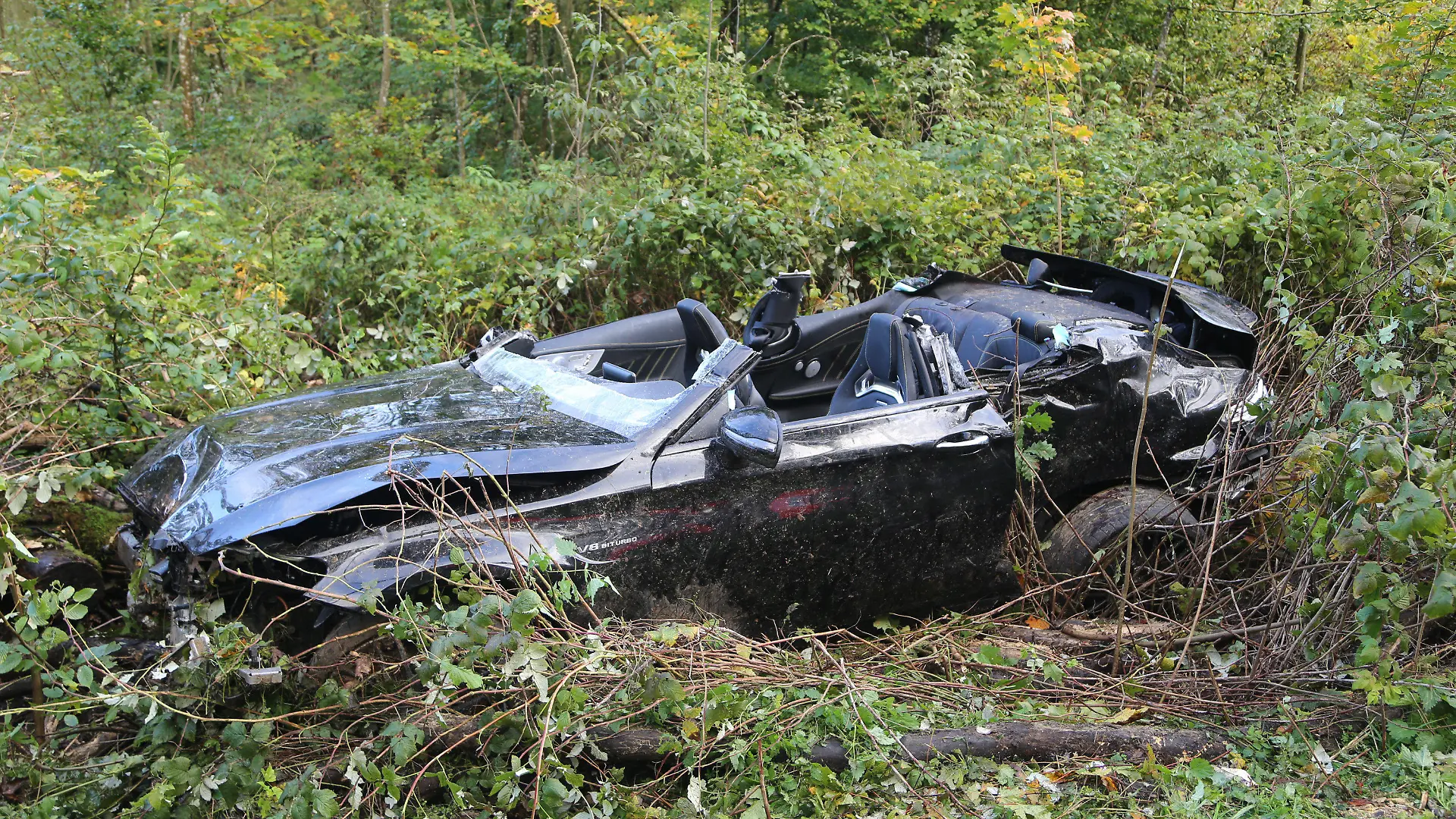 ARCHIV - 08.10.2017, Baden-Württemberg, Amstetten: Ein bei einem Unfall zerstörter Sportwagen liegt in der Nähe von Amstetten in Büschen neben der Fahrbahn. Bei dem Unfall waren nach Angaben der Polizei eine 24 Jahre alte Frau und ein 15-Jähriger ums Leben gekommen und der 27 Jahre alte Fahrer und ein 16-Jähriger schwer verletzt worden. Nach den Angaben kam der Wagen aus noch ungeklärter Ursache in einem Wald von der Straße ab und prallte gegen mehrere Bäume. (zu dpa: «Abgehoben bei Tempo 200 - Mann wegen fahrlässiger Tötung vor Gericht» vom 28.06.2018) Foto: Thomas Pöppel/dpa +++ dpa-Bildfunk +++