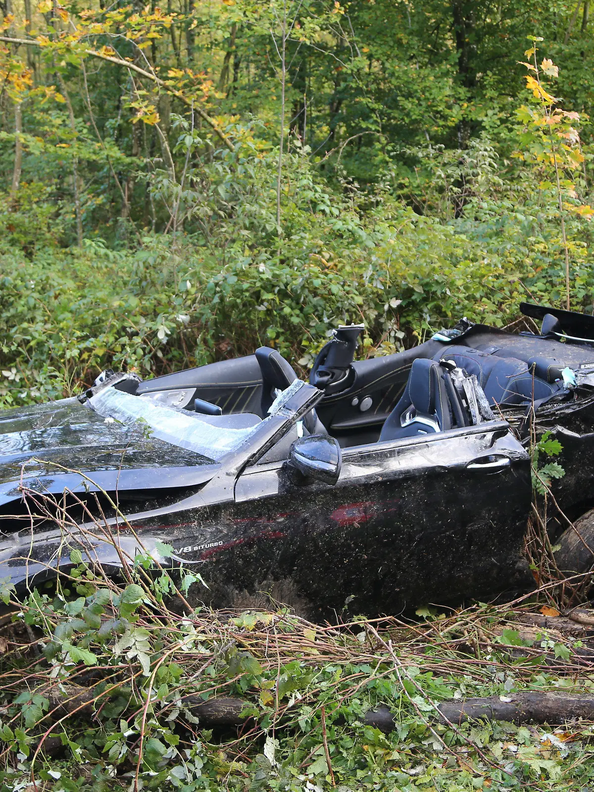 ARCHIV - 08.10.2017, Baden-Württemberg, Amstetten: Ein bei einem Unfall zerstörter Sportwagen liegt in der Nähe von Amstetten in Büschen neben der Fahrbahn. Bei dem Unfall waren nach Angaben der Polizei eine 24 Jahre alte Frau und ein 15-Jähriger ums Leben gekommen und der 27 Jahre alte Fahrer und ein 16-Jähriger schwer verletzt worden. Nach den Angaben kam der Wagen aus noch ungeklärter Ursache in einem Wald von der Straße ab und prallte gegen mehrere Bäume. (zu dpa: «Abgehoben bei Tempo 200 - Mann wegen fahrlässiger Tötung vor Gericht» vom 28.06.2018) Foto: Thomas Pöppel/dpa +++ dpa-Bildfunk +++