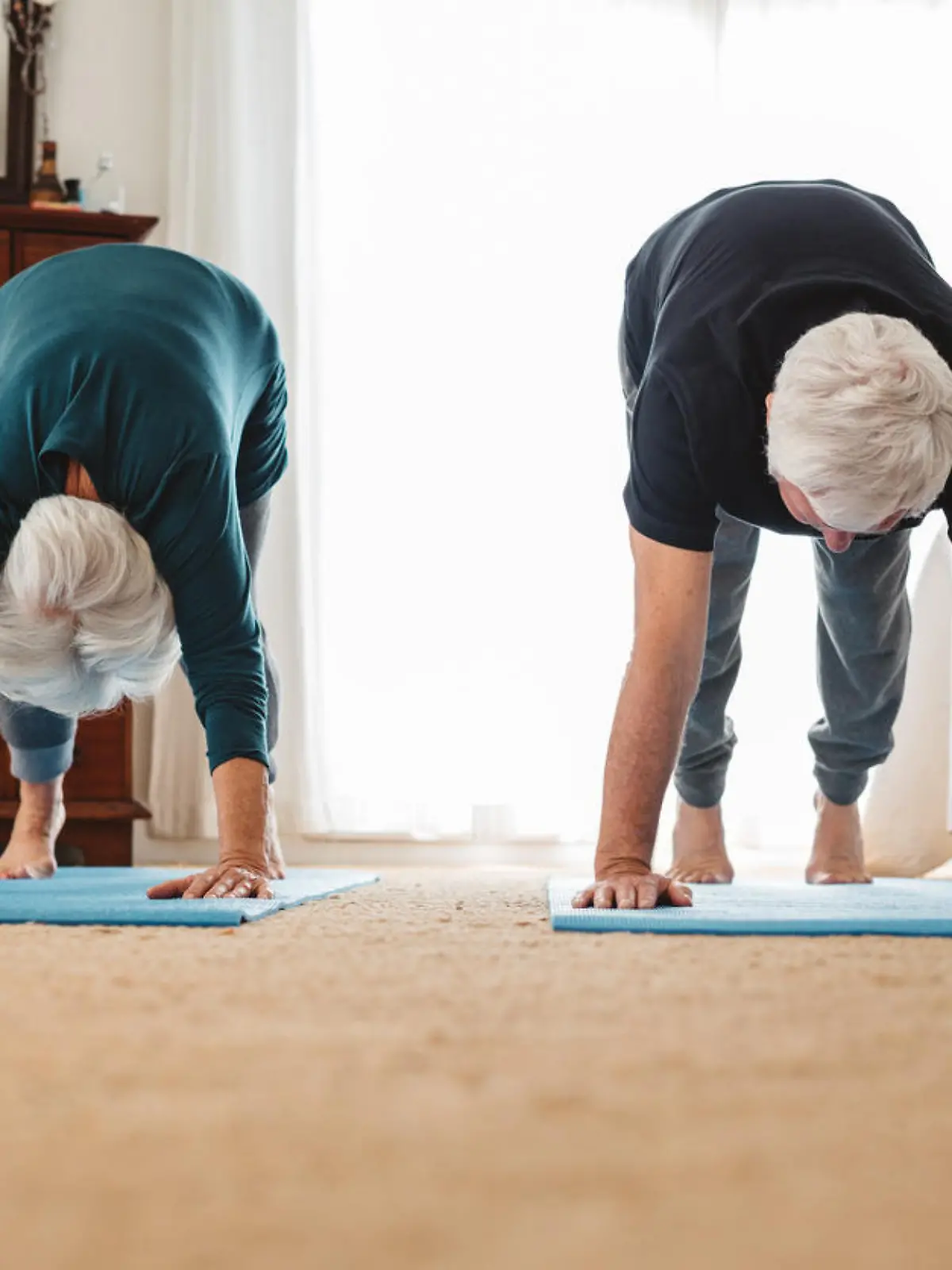 Älteres Paar macht zu Hause Yoga