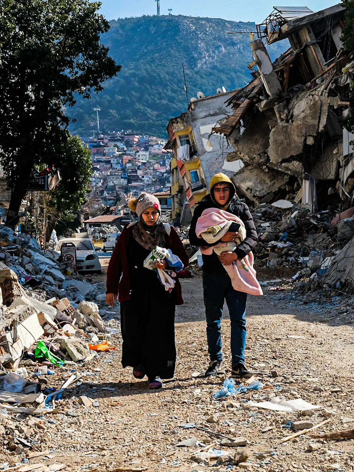 dpatopbilder - 12.02.2023, Türkei, Hatay: Eine Frau und ein junger Mann gehen durch die Trümmer des verheerenden Erdbebens vom 06.02.2023. Eine Woche nach dem Erdbeben im türkisch-syrischen Grenzgebiet ist die Zahl der Toten auf mehr als 30 000 gestiegen. Foto: Murat Kocabas/SOPA Images via ZUMA Press Wire/dpa +++ dpa-Bildfunk +++