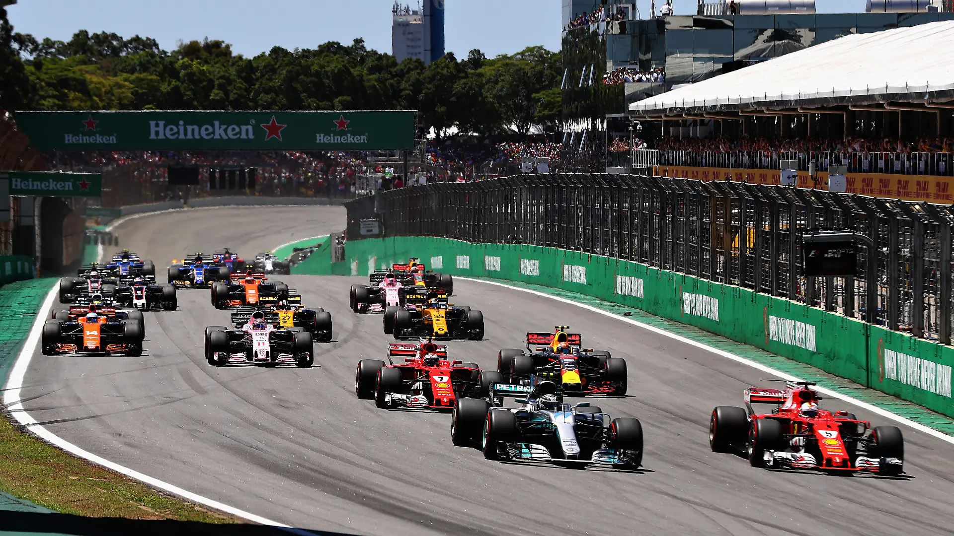 SAO PAULO, BRAZIL - NOVEMBER 12: Sebastian Vettel of Germany driving the (5) Scuderia Ferrari SF70H and Valtteri Bottas driving the (77) Mercedes AMG Petronas F1 Team Mercedes F1 WO8 lead the field towards turn one at the start during the Formula One Grand Prix of Brazil at Autodromo Jose Carlos Pace on November 12, 2017 in Sao Paulo, Brazil. (Photo by Mark Thompson/Getty Images)