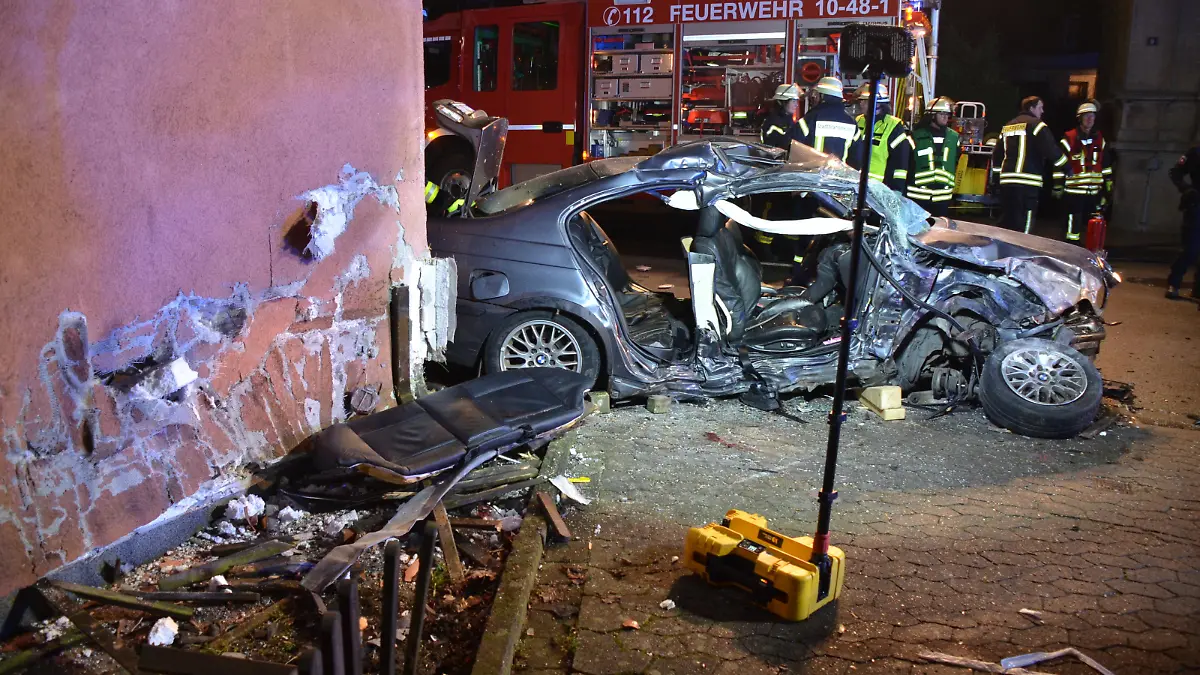 total zerstörter BMW und beschädigtes Haus