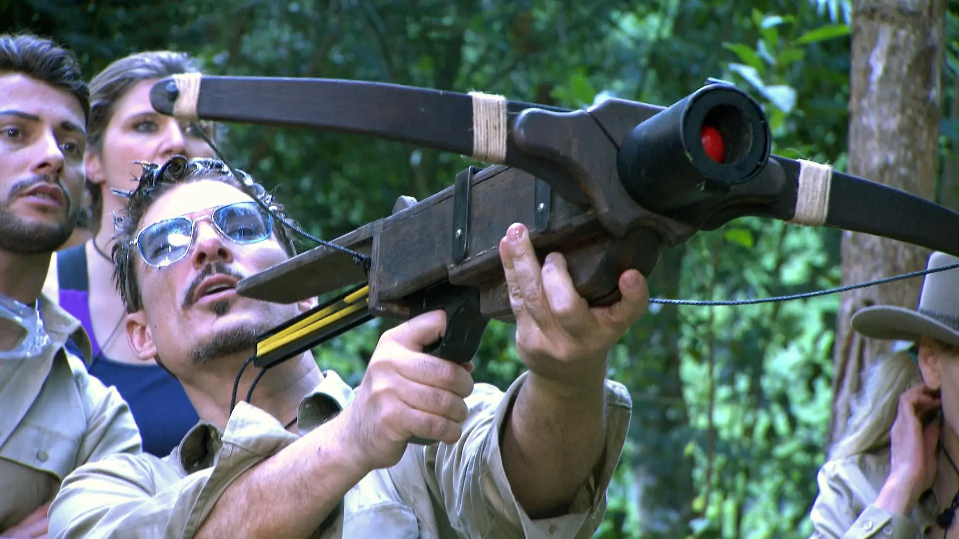 Tag 1 - Dschungelprüfung "Starschuss". Chris Töpperwien hat mit seinem Mund zwei Bälle aus den Behältern voller Kakerlaken, Maden und Schleim rausgefischt. Die erkämpften Bälle dienen als Munition für eine Armbrust. Für jeden Treffer auf Tierschilder in einem Baum gibt es einen Stern.