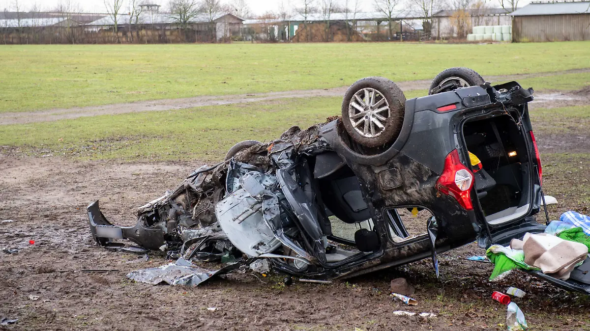 Blick auf einen verunfallten Wagen neben einer Straße. Bei einem schweren Verkehrsunfall an der Grenze zwischen Schleswig-Holstein und Mecklenburg-Vorpommern sind drei Menschen ums Leben gekommen.