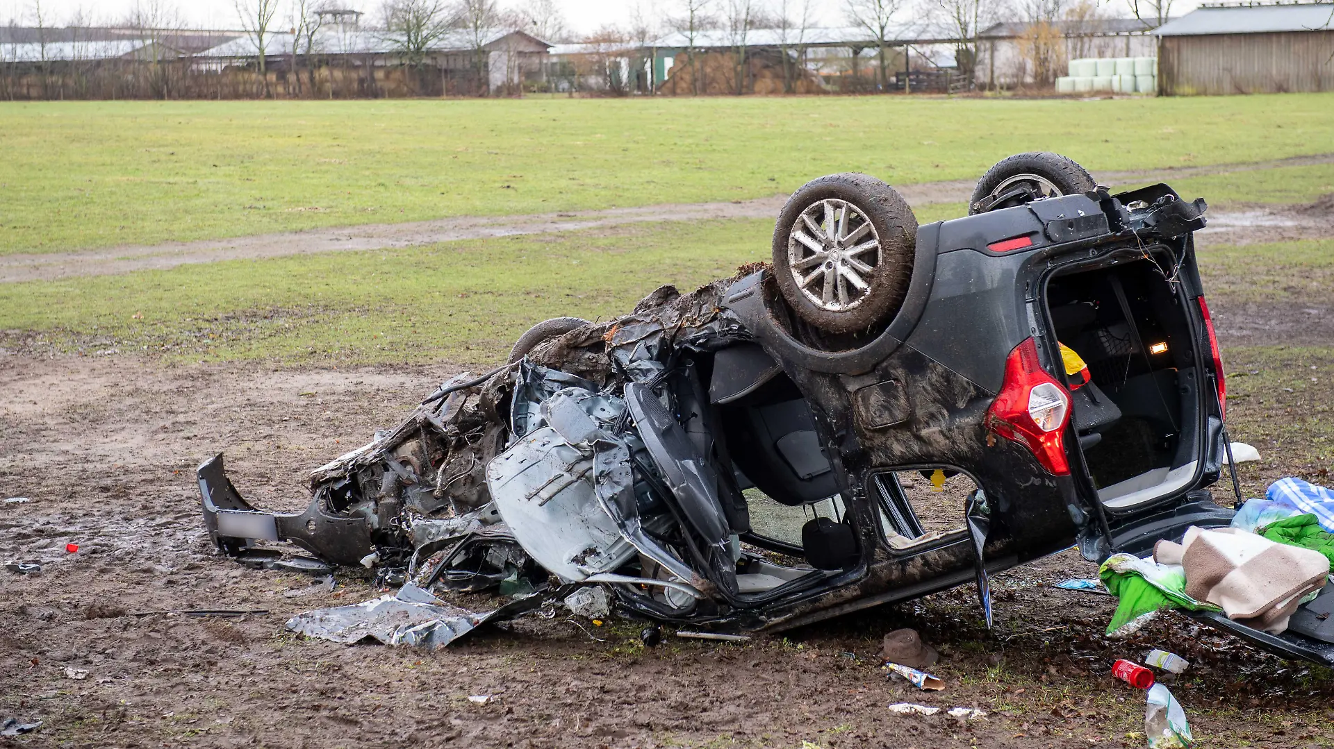 Blick auf einen verunfallten Wagen neben einer Straße. Bei einem schweren Verkehrsunfall an der Grenze zwischen Schleswig-Holstein und Mecklenburg-Vorpommern sind drei Menschen ums Leben gekommen.