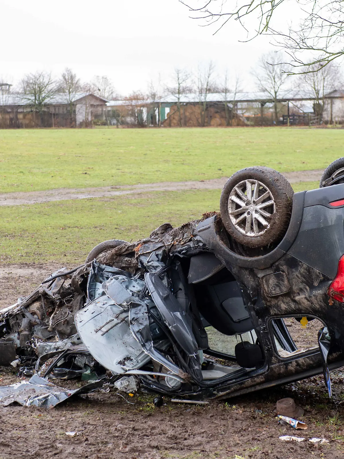 Blick auf einen verunfallten Wagen neben einer Straße. Bei einem schweren Verkehrsunfall an der Grenze zwischen Schleswig-Holstein und Mecklenburg-Vorpommern sind drei Menschen ums Leben gekommen.