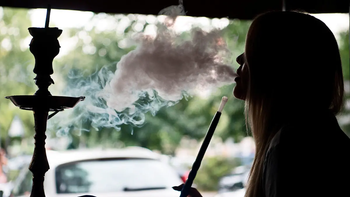 ARCHIV - ILLUSTRATION - Eine junge Frau raucht am 21.07.2016 in einer Shisha-Bar in Berlin Tabak der Sorte «Traube-Minze» in einer Wasserpfeife. Shisha-Rauchen liegt im Trend: Die arabische Wasserpfeife ist besonders bei jungen Leuten beliebt. In den Großstädten haben sich zahllose Shisha-Bars etabliert. Es gibt eine Shisha-Messe und einen Shisha-Verband. Doch nun mehren sich die Alarmsignale. (zu dpa: "Risiken und Nebenwirkungen: Ärzte warnen vor Shisha-Trend") Foto: Soeren Stache/dpa +++(c) dpa - Bildfunk+++