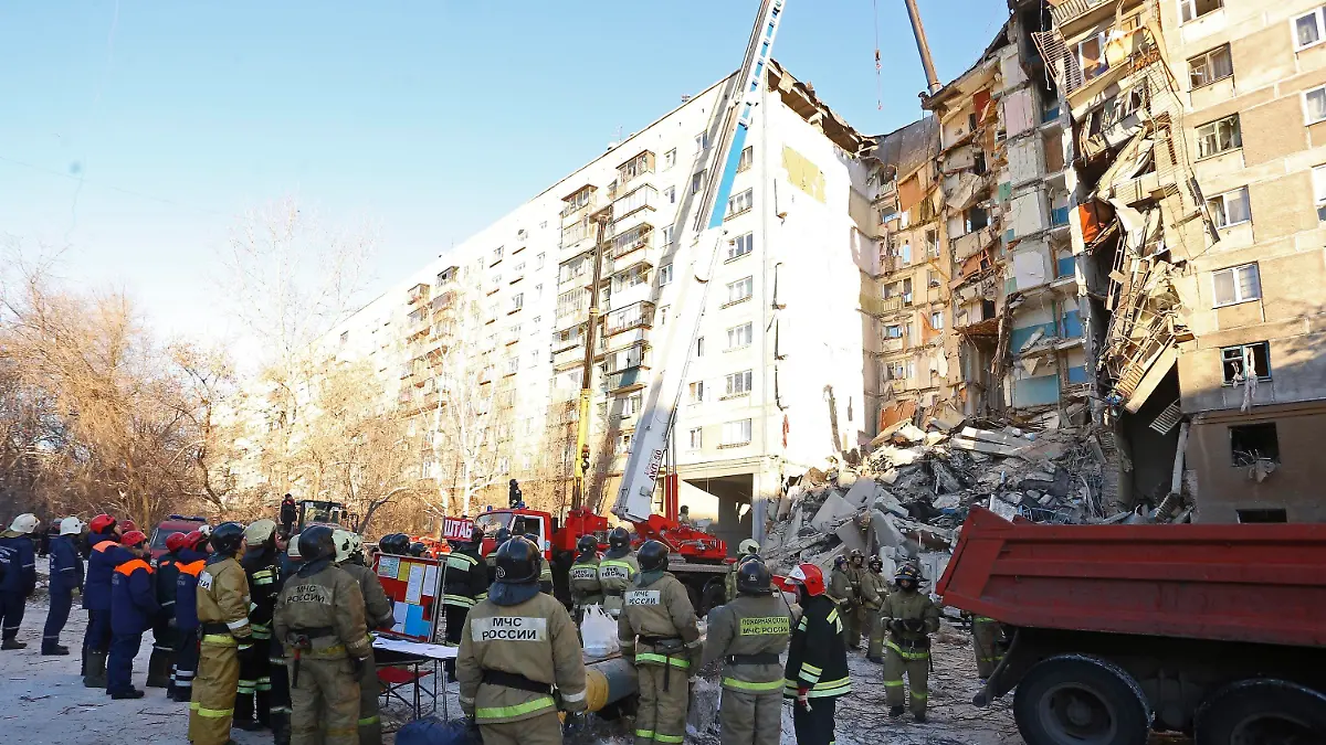 31.12.2018, Russland, Magnitogorsk: Rettungskräfte stehen vor einem Wohnhaus, das durch eine Gasexplosion beschädigt worden ist. Bis zum Montagmittag (Ortszeit) sprachen die Behörden von mindestens vier Toten. Zehn Menschen seien verletzt gerettet worden. Foto: Maxim Shmakov/AP/dpa +++ dpa-Bildfunk +++
