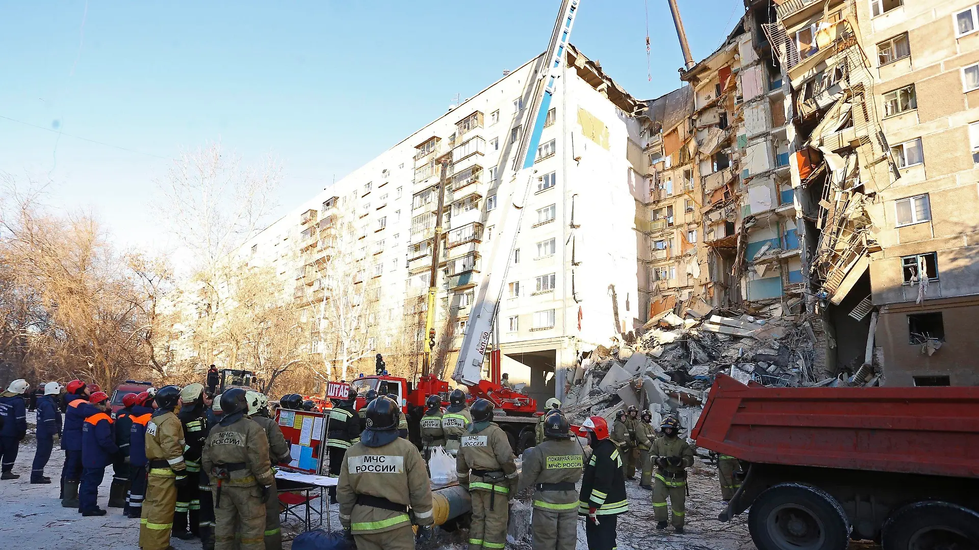 31.12.2018, Russland, Magnitogorsk: Rettungskräfte stehen vor einem Wohnhaus, das durch eine Gasexplosion beschädigt worden ist. Bis zum Montagmittag (Ortszeit) sprachen die Behörden von mindestens vier Toten. Zehn Menschen seien verletzt gerettet worden. Foto: Maxim Shmakov/AP/dpa +++ dpa-Bildfunk +++