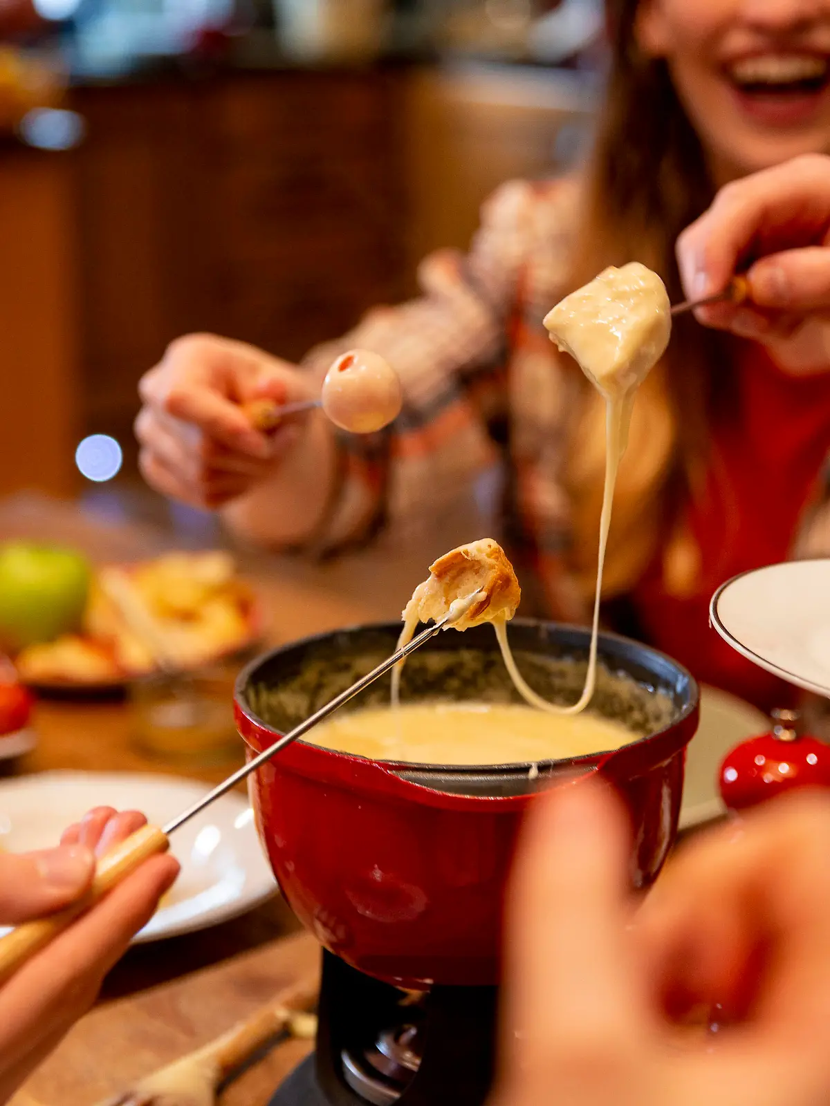 A group of work colleagues eat fondue together on a team bonding trip.