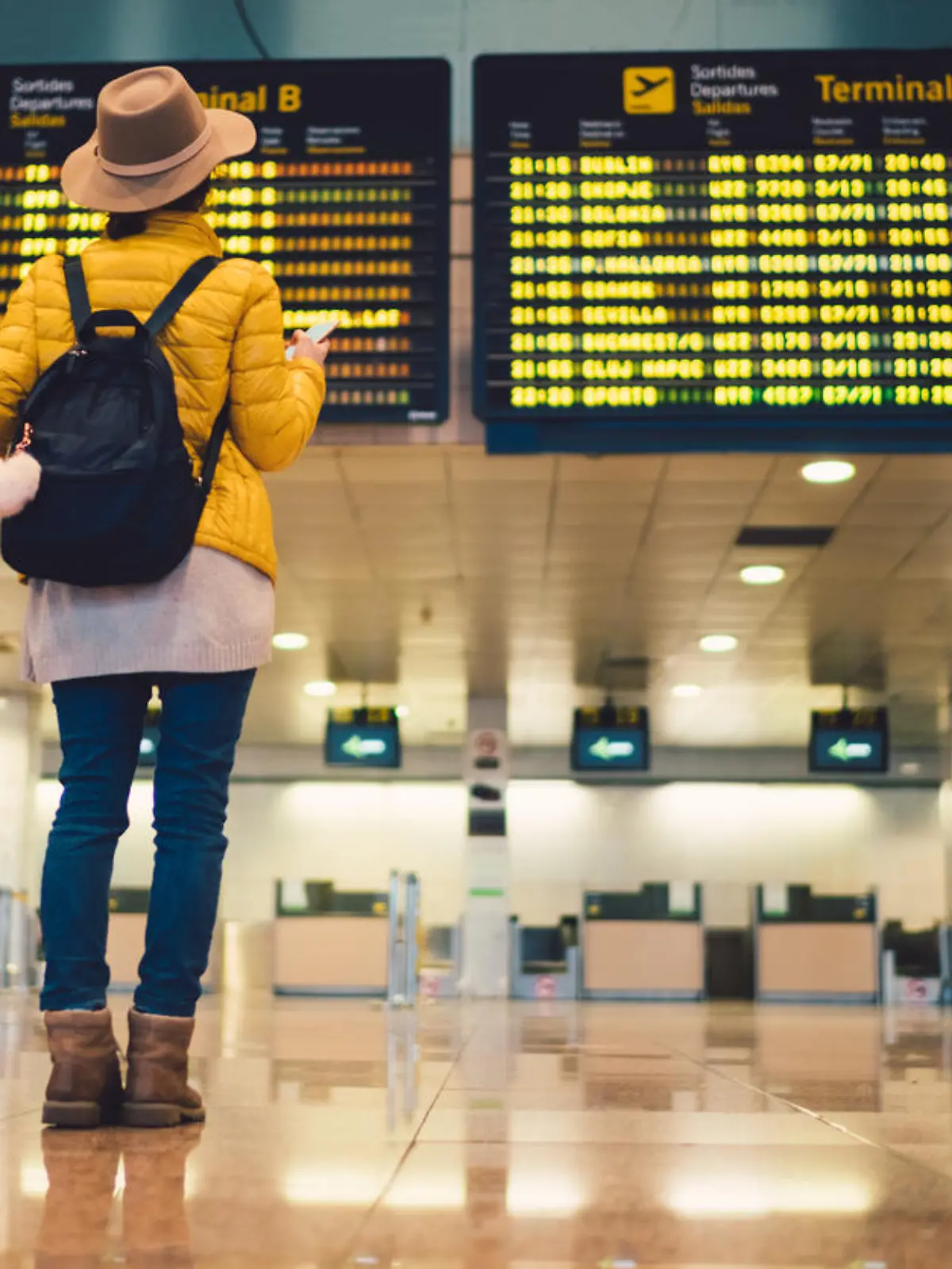 Young woman at the airport in Barcelona checking for the flight schedule