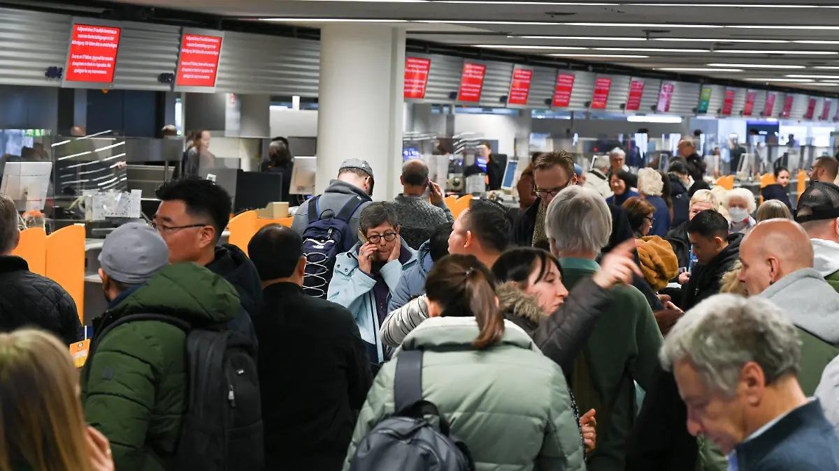 dpatopbilder - 15.02.2023, Hessen, Frankfurt/Main: Zahlreiche Fluggäste stehen im Terminal 1 im Flughafen Frankfurt vor einem Informationsschalter der Lufthansa Schlange. Wegen einer IT-Panne beim Lufthansa-Konzern sind am Mittwoch (15.02.2023 ) Tausende Passagiere von Verspätungen und Flugausfällen betroffen. Foto: Arne Dedert/dpa +++ dpa-Bildfunk +++
