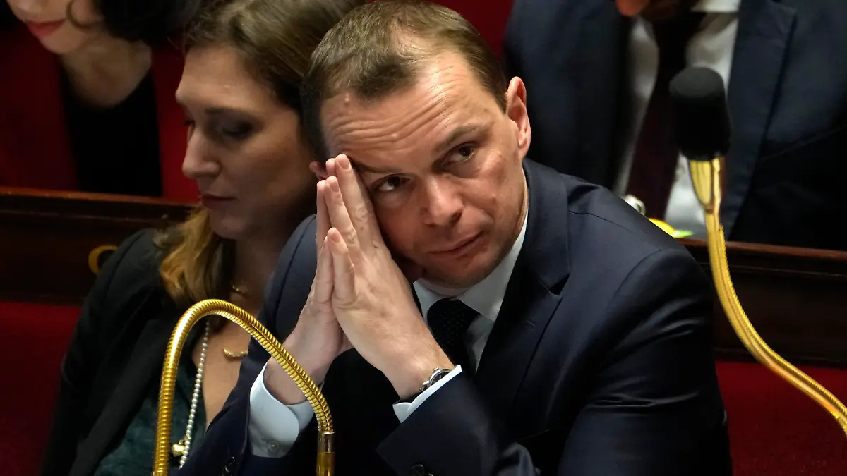 French Labor Minister Olivier Dussopt listens to debates during the Questions to the Government session at the National Assembly, Tuesday, Feb. 14, 2023 in Paris. French lawmakers began a rowdy debate earlier this week on the pension bill to raise the minimum retirement age for a full state pension from 62 to 64. It's the flagship legislation of Macron's second term. (AP Photo/Thibault Camus)