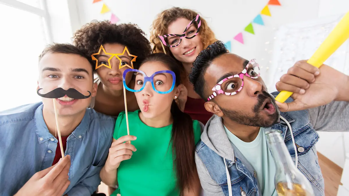 corporate, celebration and holidays concept - happy friends or team with party accessories having fun at office