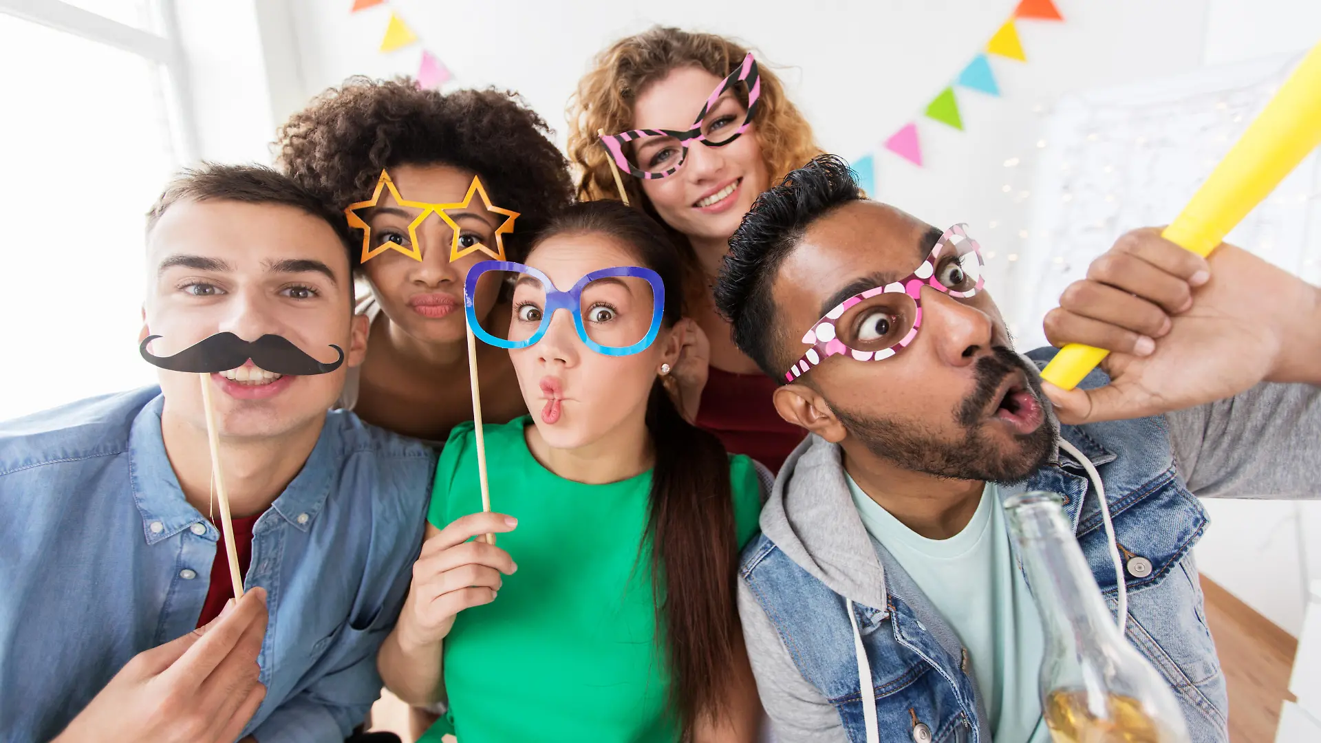 corporate, celebration and holidays concept - happy friends or team with party accessories having fun at office
