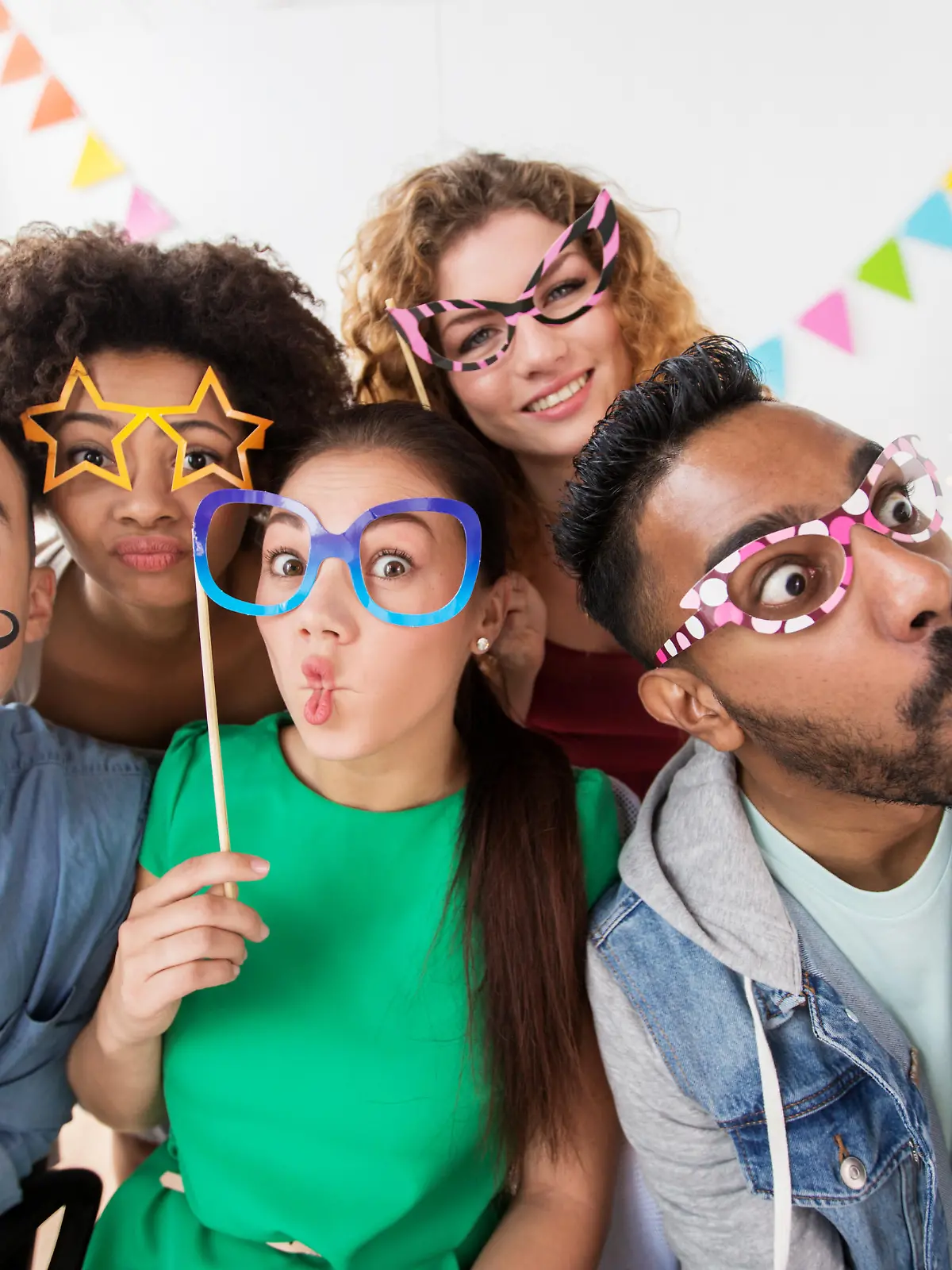 corporate, celebration and holidays concept - happy friends or team with party accessories having fun at office